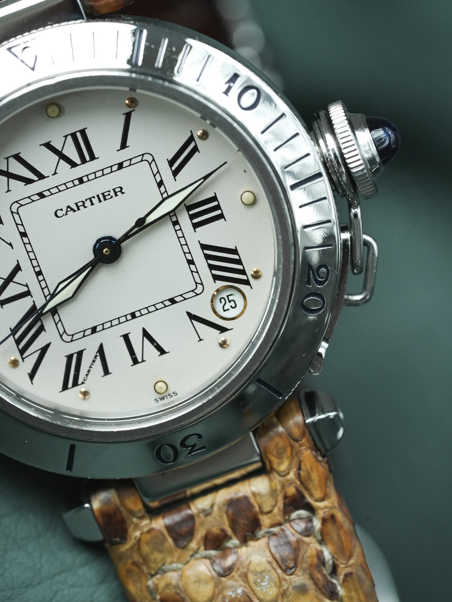 Montre Nina Ricci vintage au boîtier doré et bracelet en cuir marron foncé.