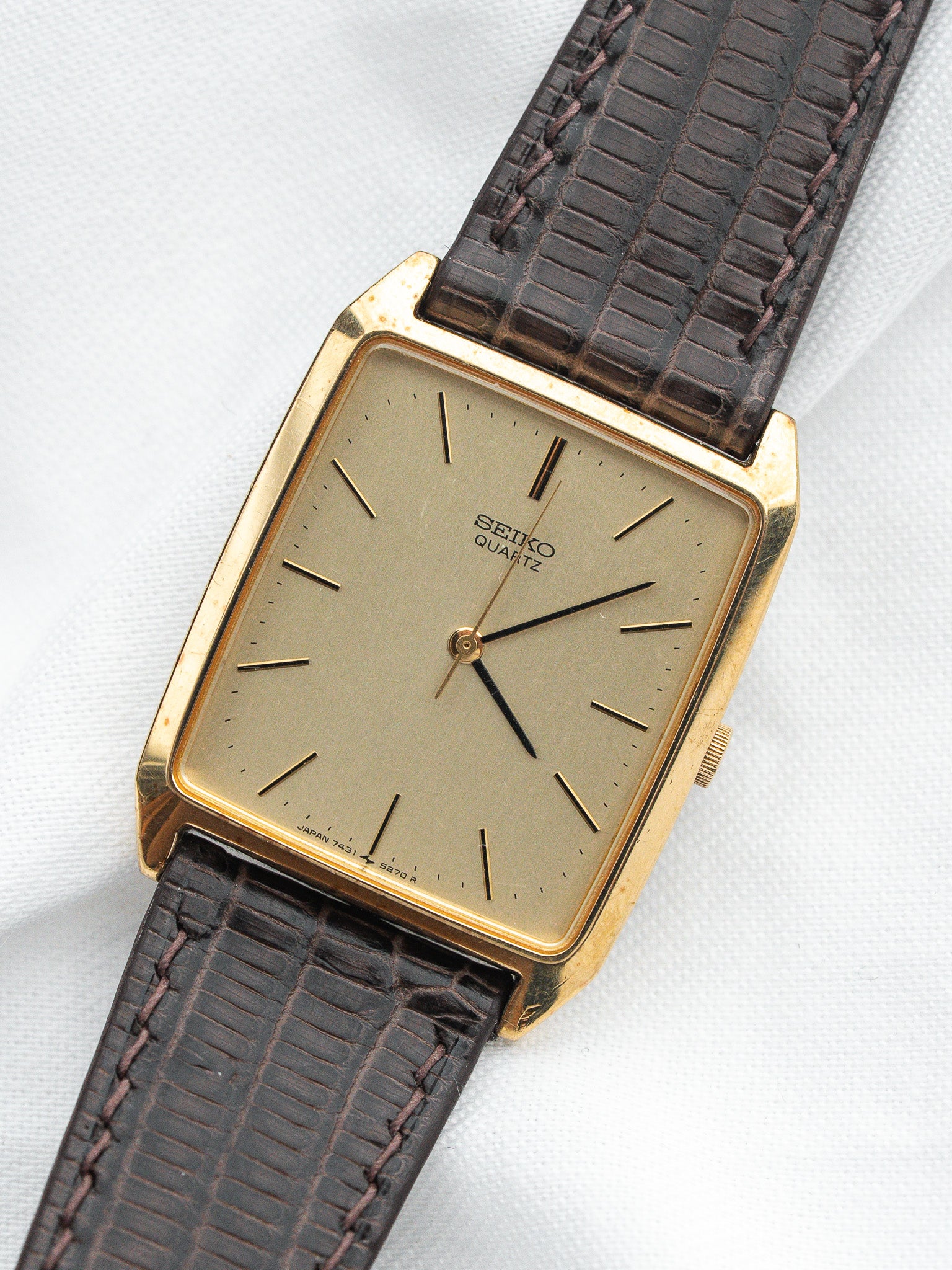 Seiko Quartz vintage watch with gold case, beige dial, and brown leather strap