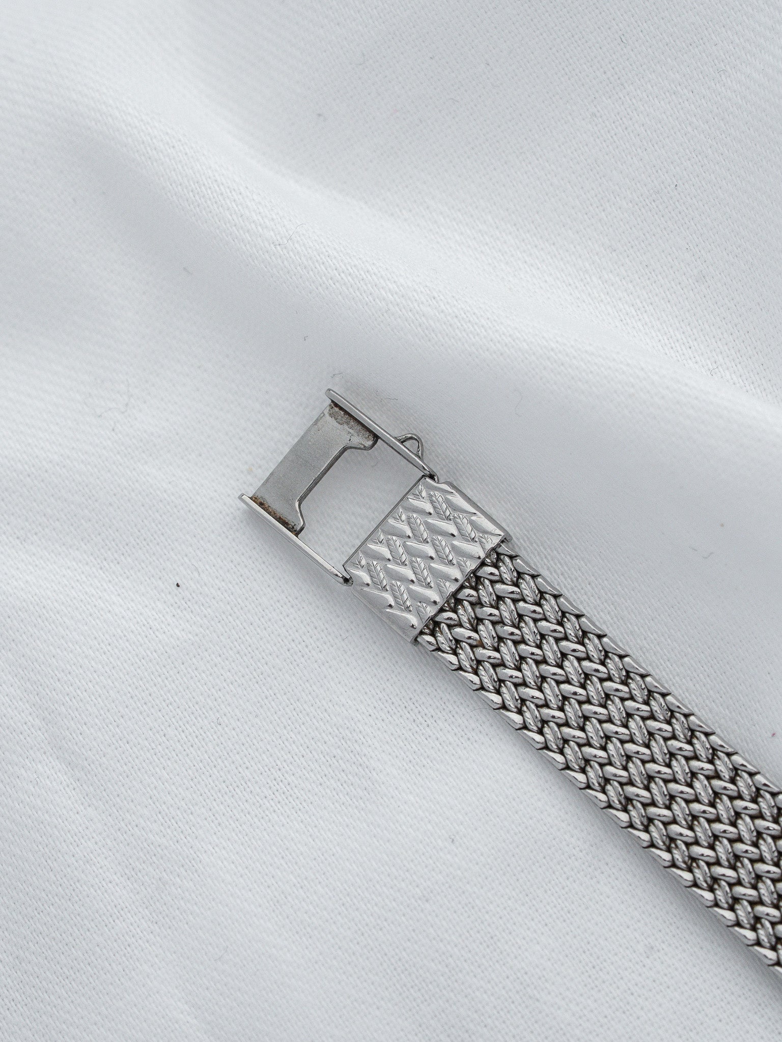 Vintage metal watch bracelet with textured mesh design and engraved clasp