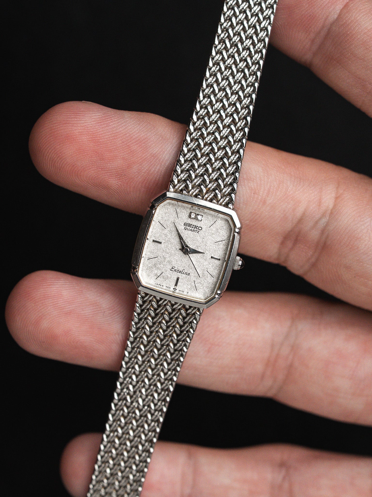 Vintage Seiko Exceline quartz watch with silver dial and mesh bracelet held in hand