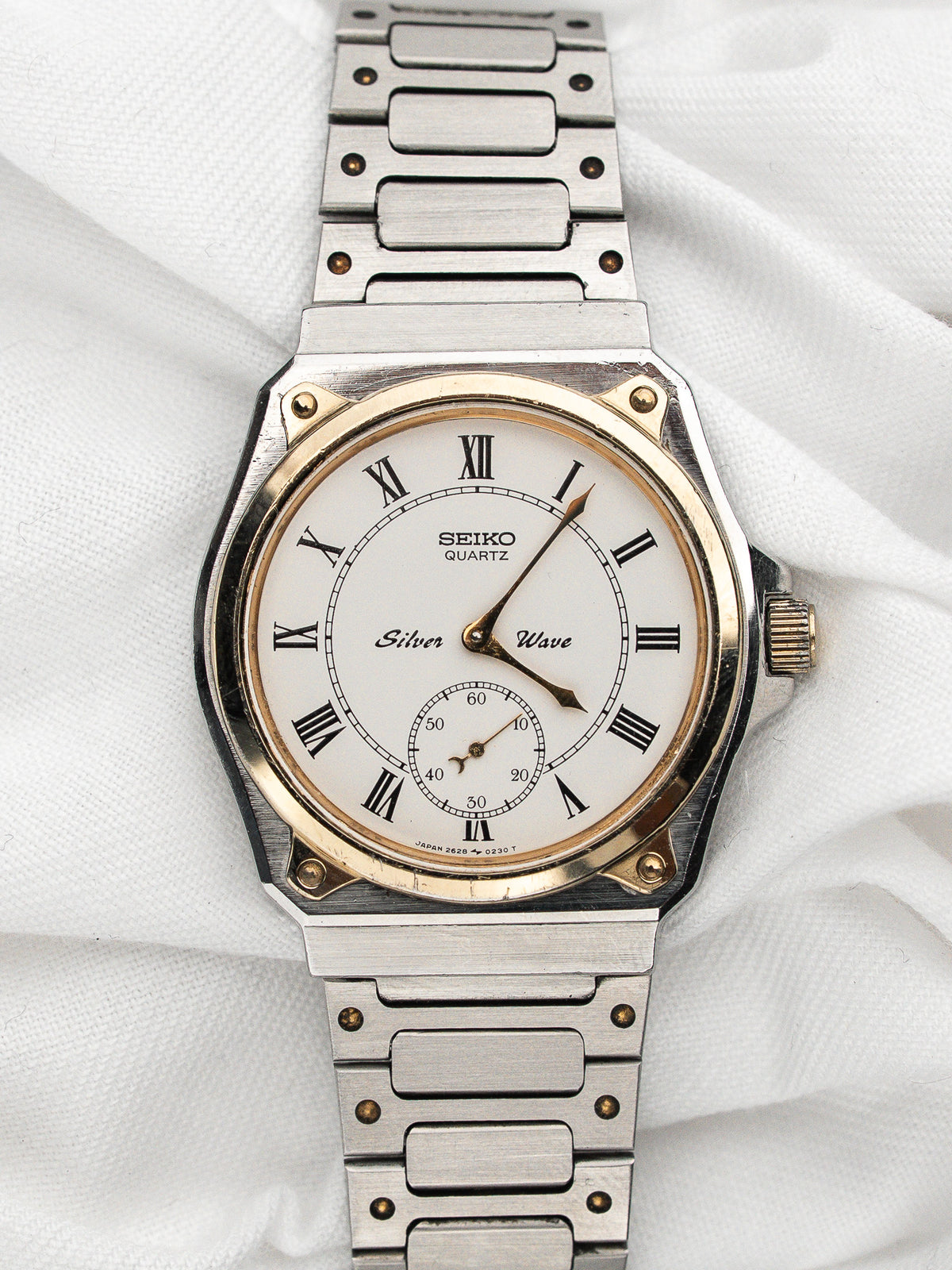 Vintage Seiko Silver Wave Watch in steel and gold, white dial, on a white background