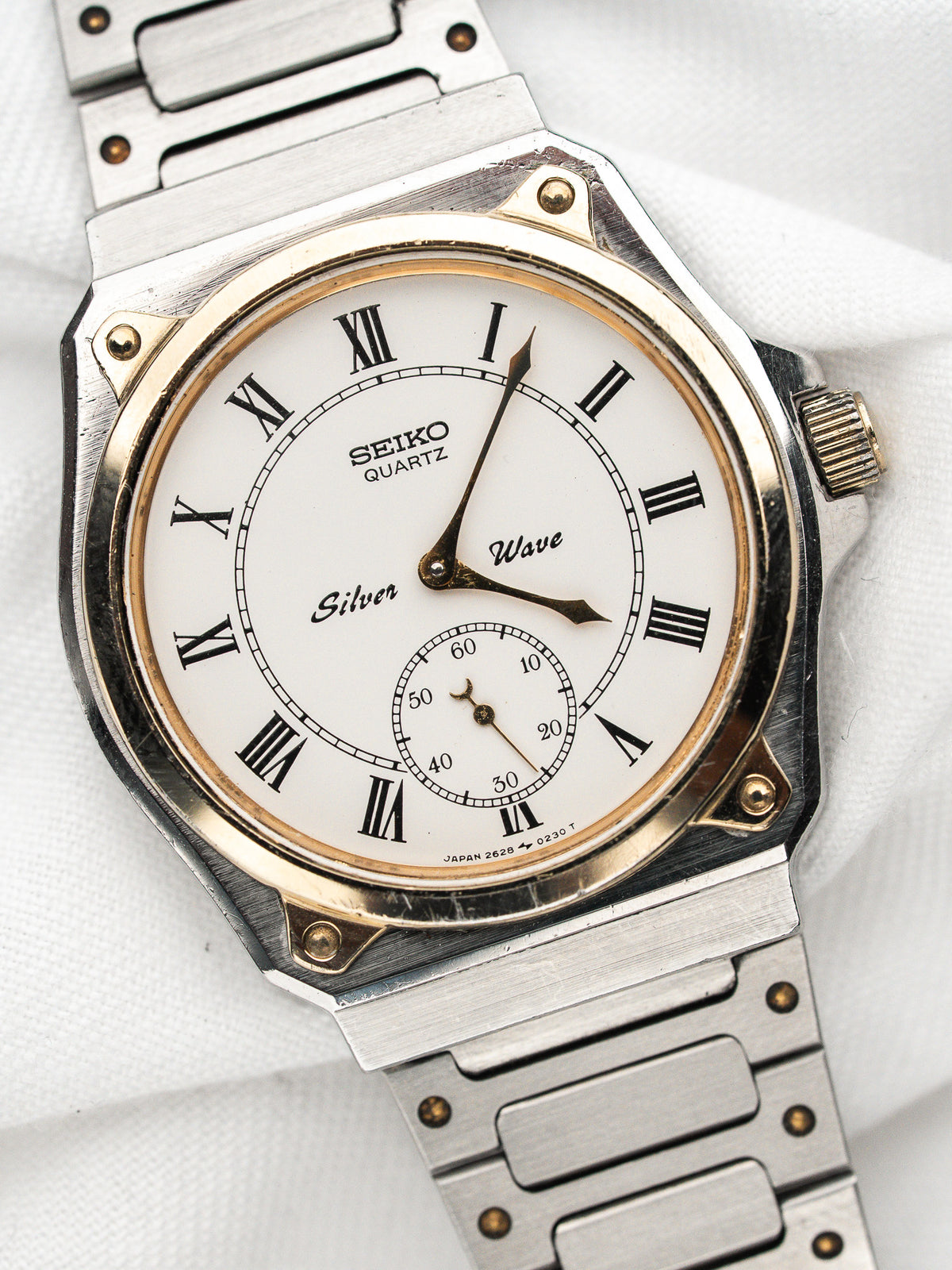 Vintage Seiko Quartz Watch in steel, white dial with Roman numerals, white background