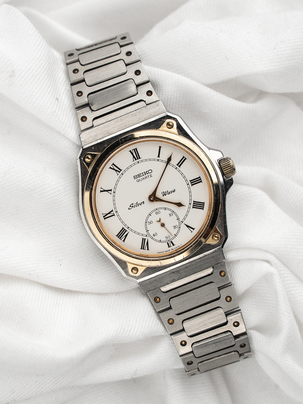 Vintage Seiko Quartz Watch in steel, white dial with Roman numerals, on white fabric