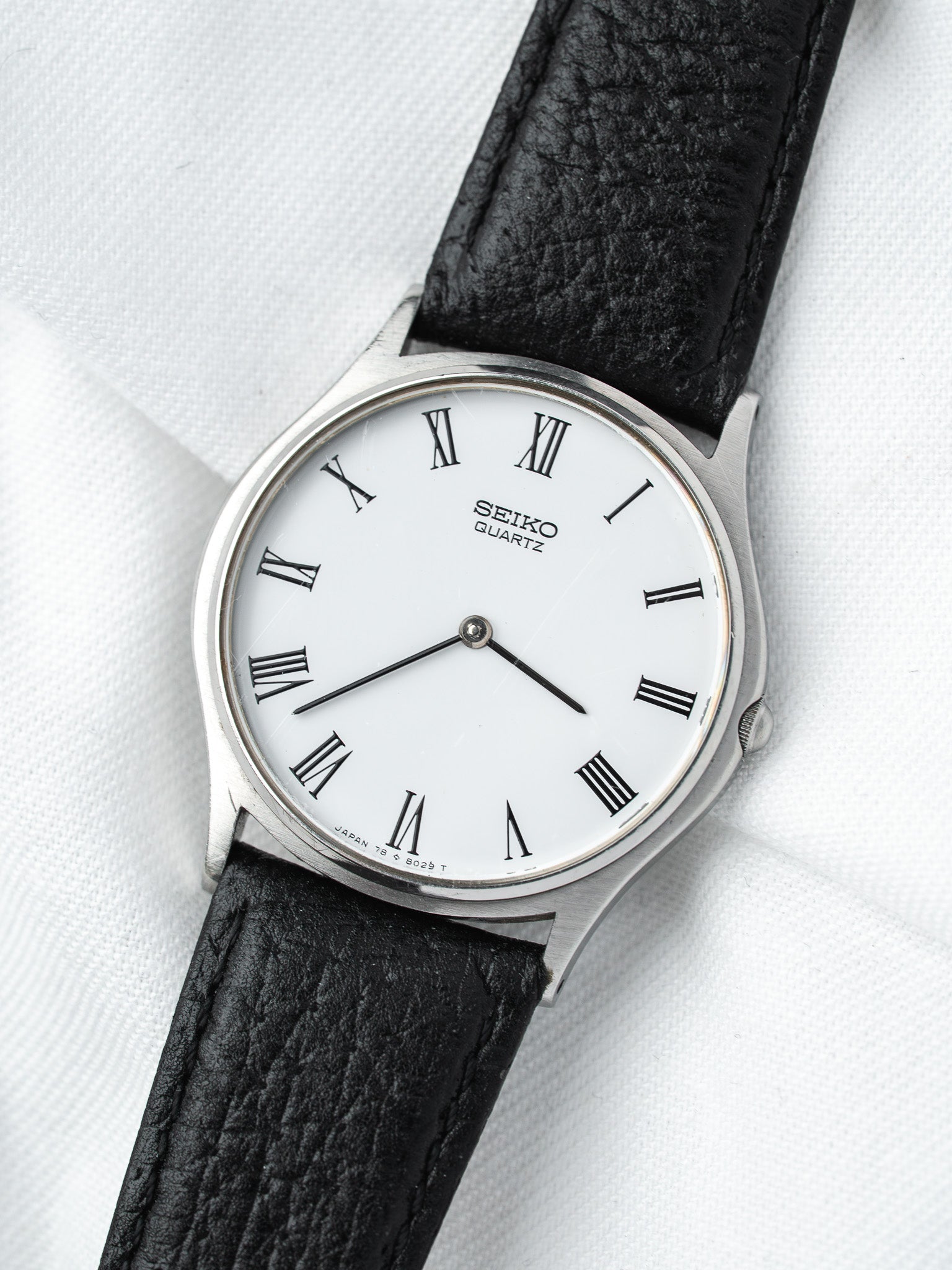 Seiko Quartz vintage watch with white dial, Roman numerals, black leather strap