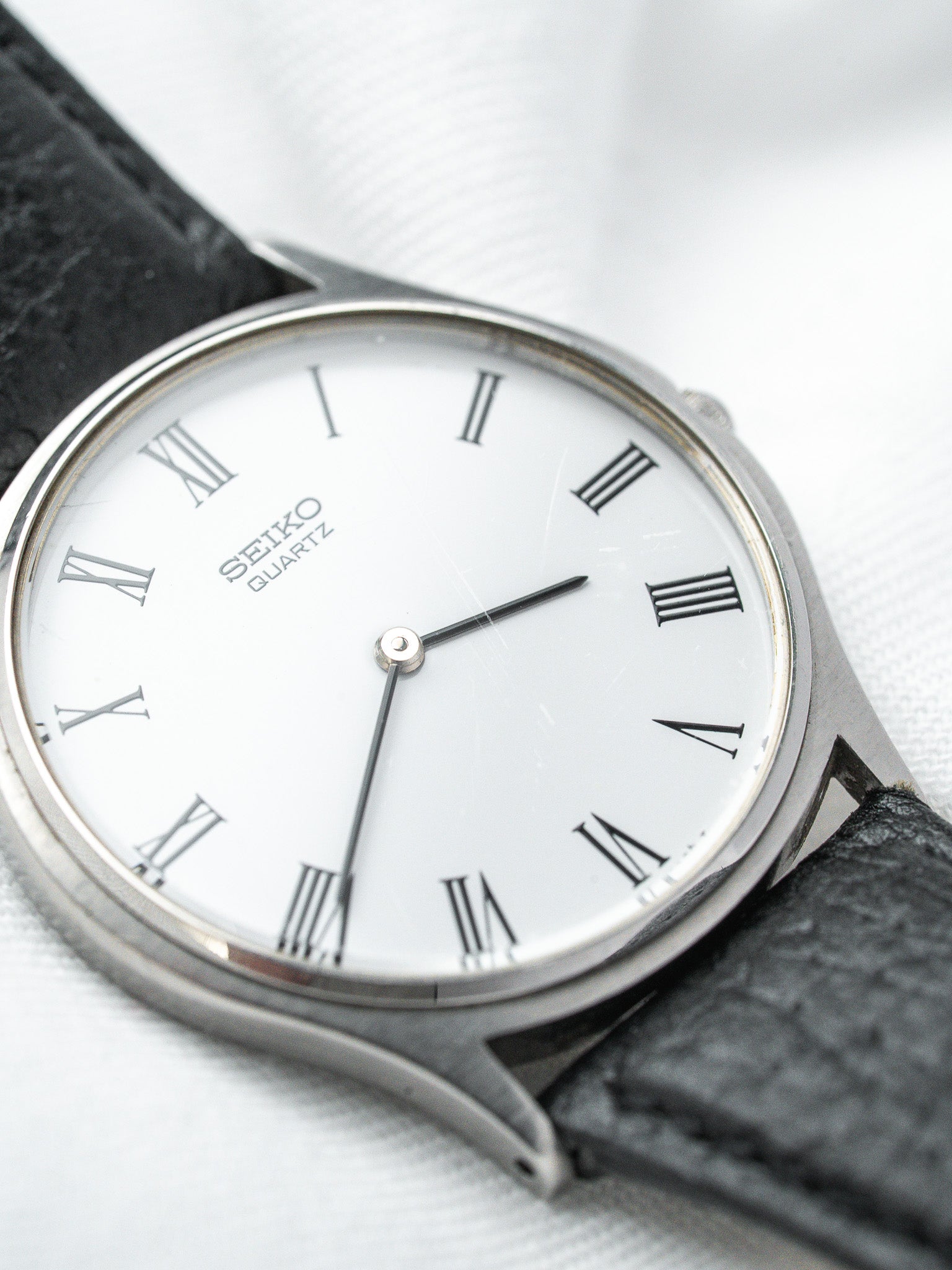Seiko Quartz vintage watch with white dial, Roman numerals, black leather strap