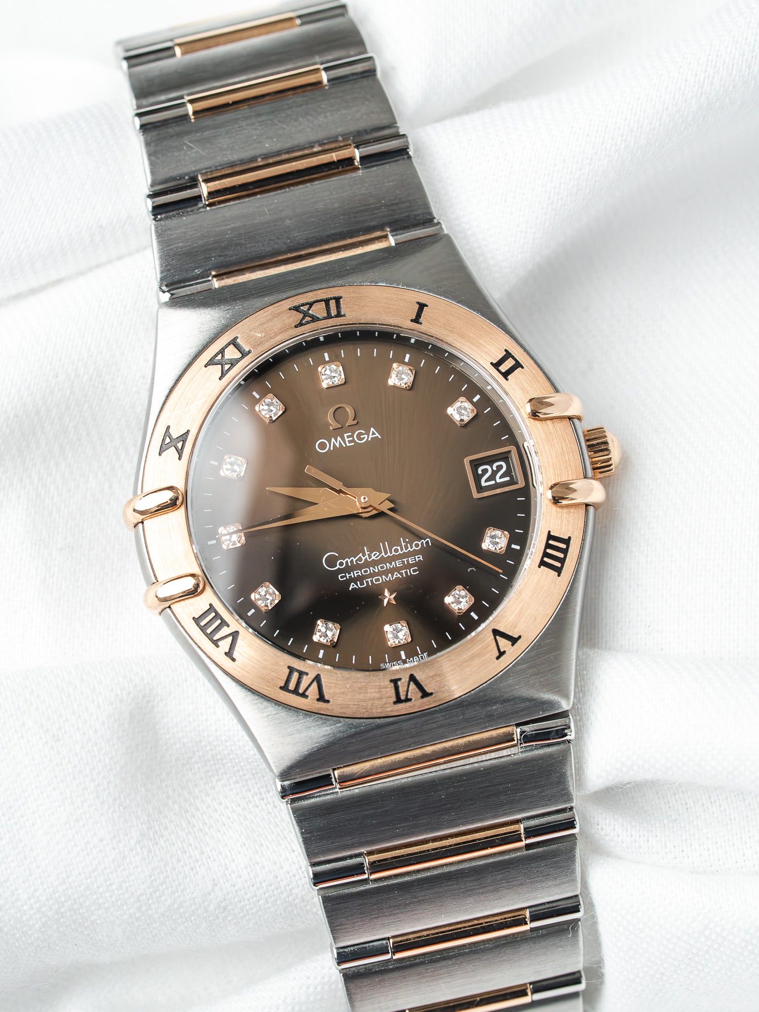 Omega Constellation automatic watch with brown dial, diamond markers, and two-tone steel and gold bracelet