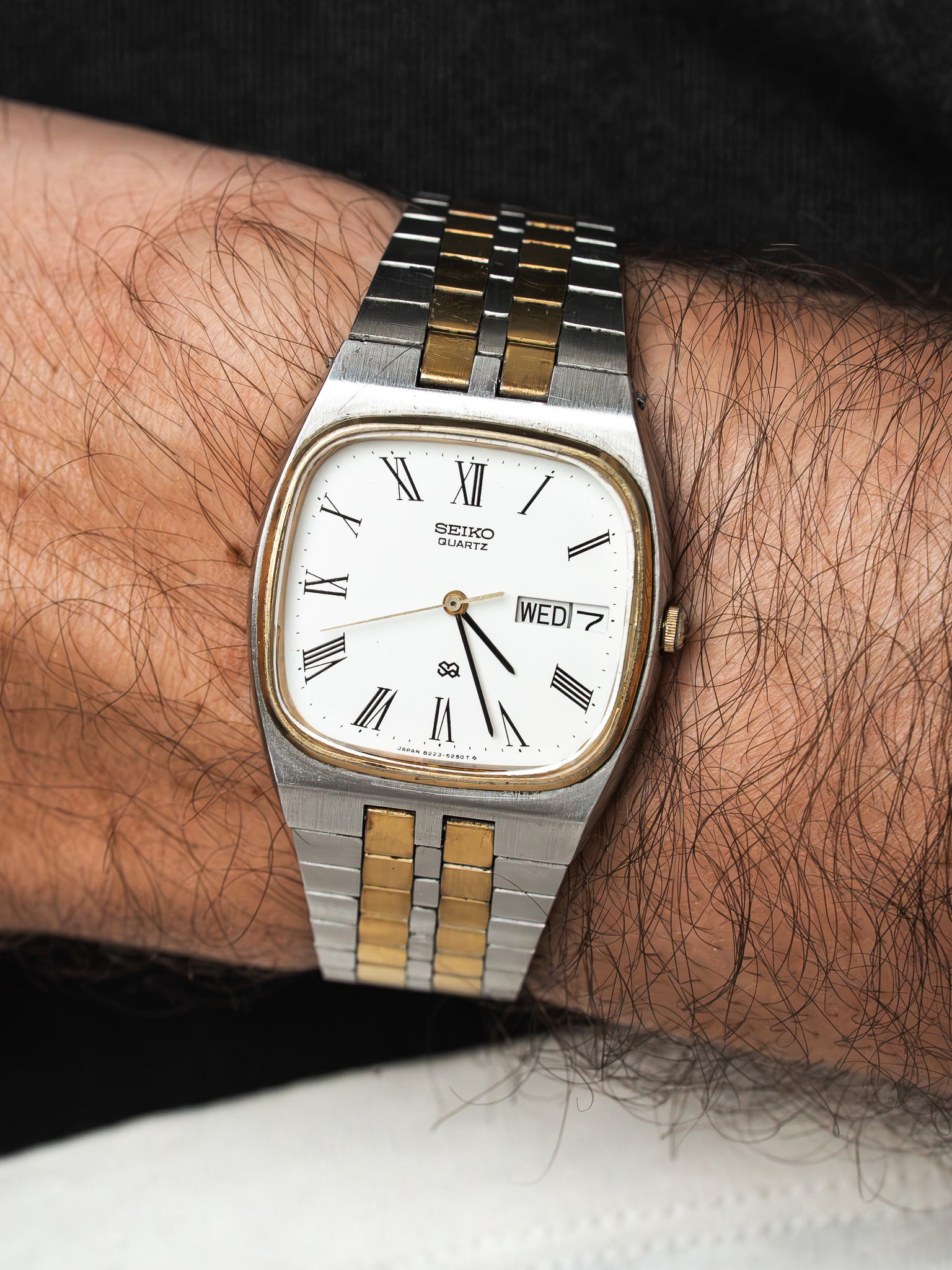 Seiko Quartz vintage watch with white dial, Roman numerals, two-tone bracelet on wrist