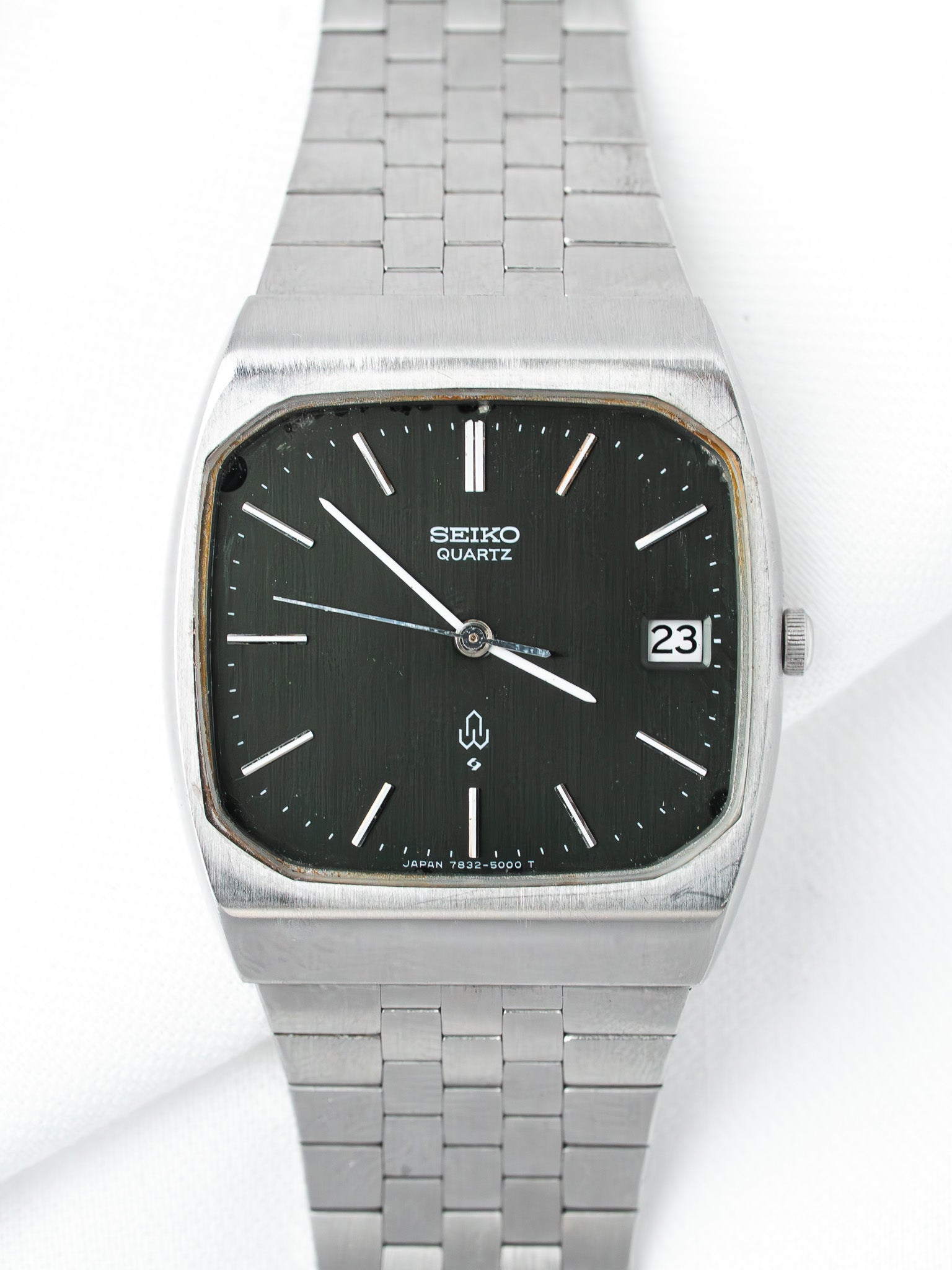 Seiko Quartz vintage watch with black dial, silver case, and metal bracelet on white background