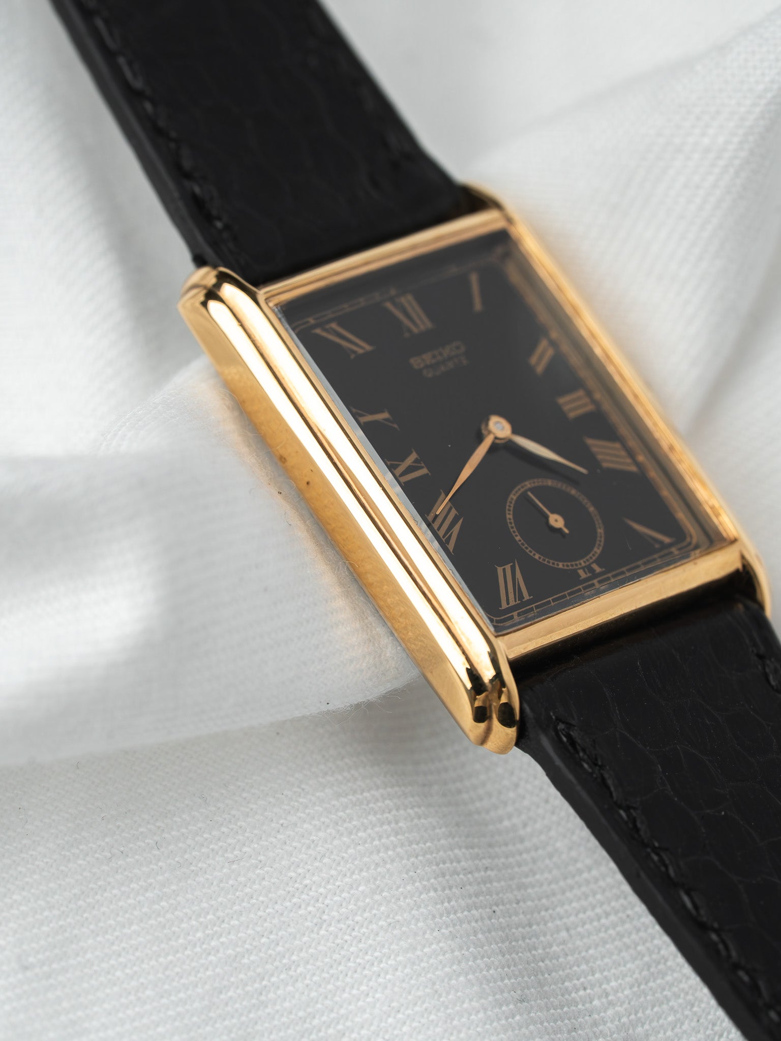 Seiko vintage watch with gold case, black dial Roman numerals, black leather strap