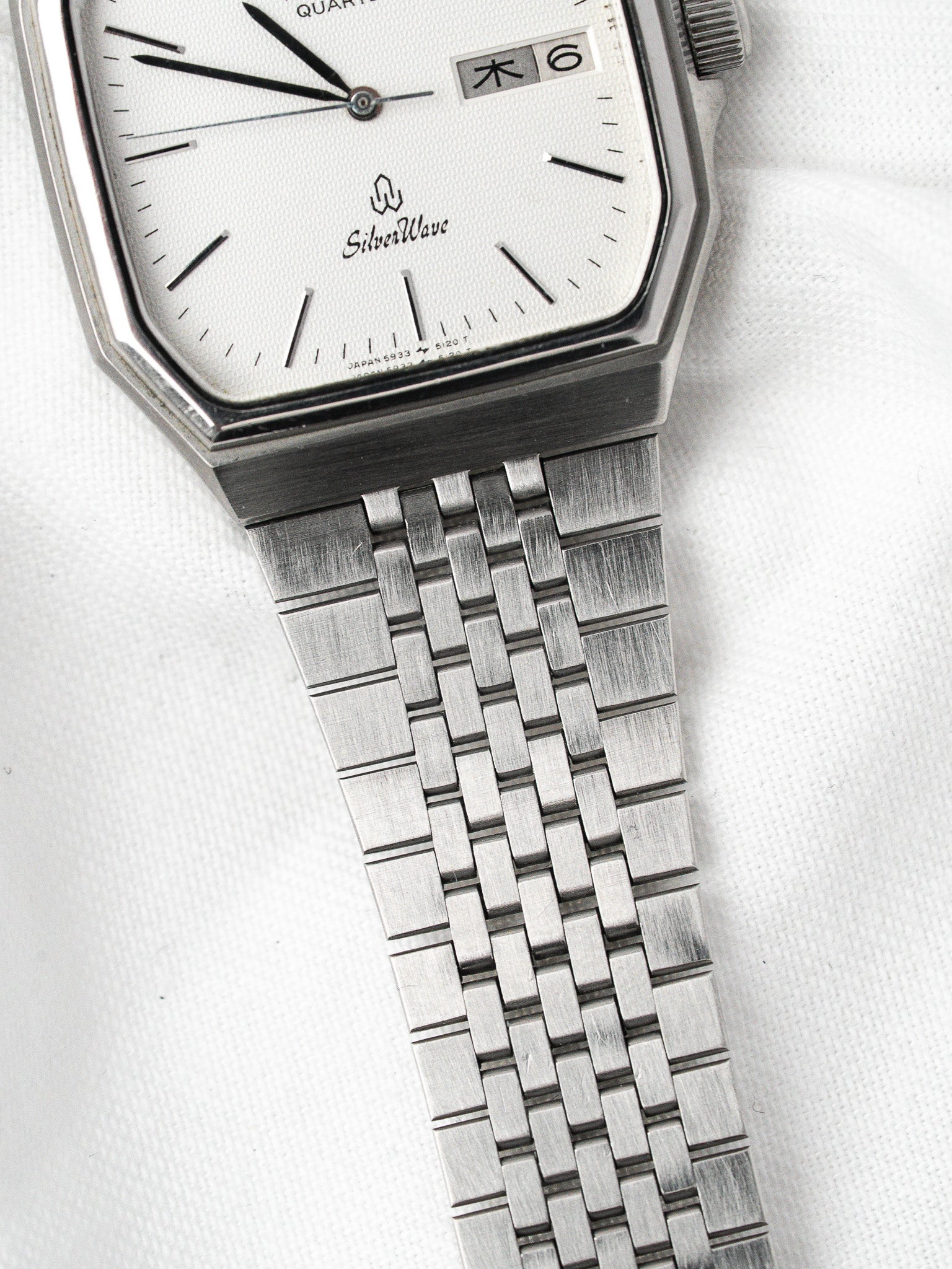 SilverWave vintage quartz watch with white dial, day-date window, and steel bracelet on white background