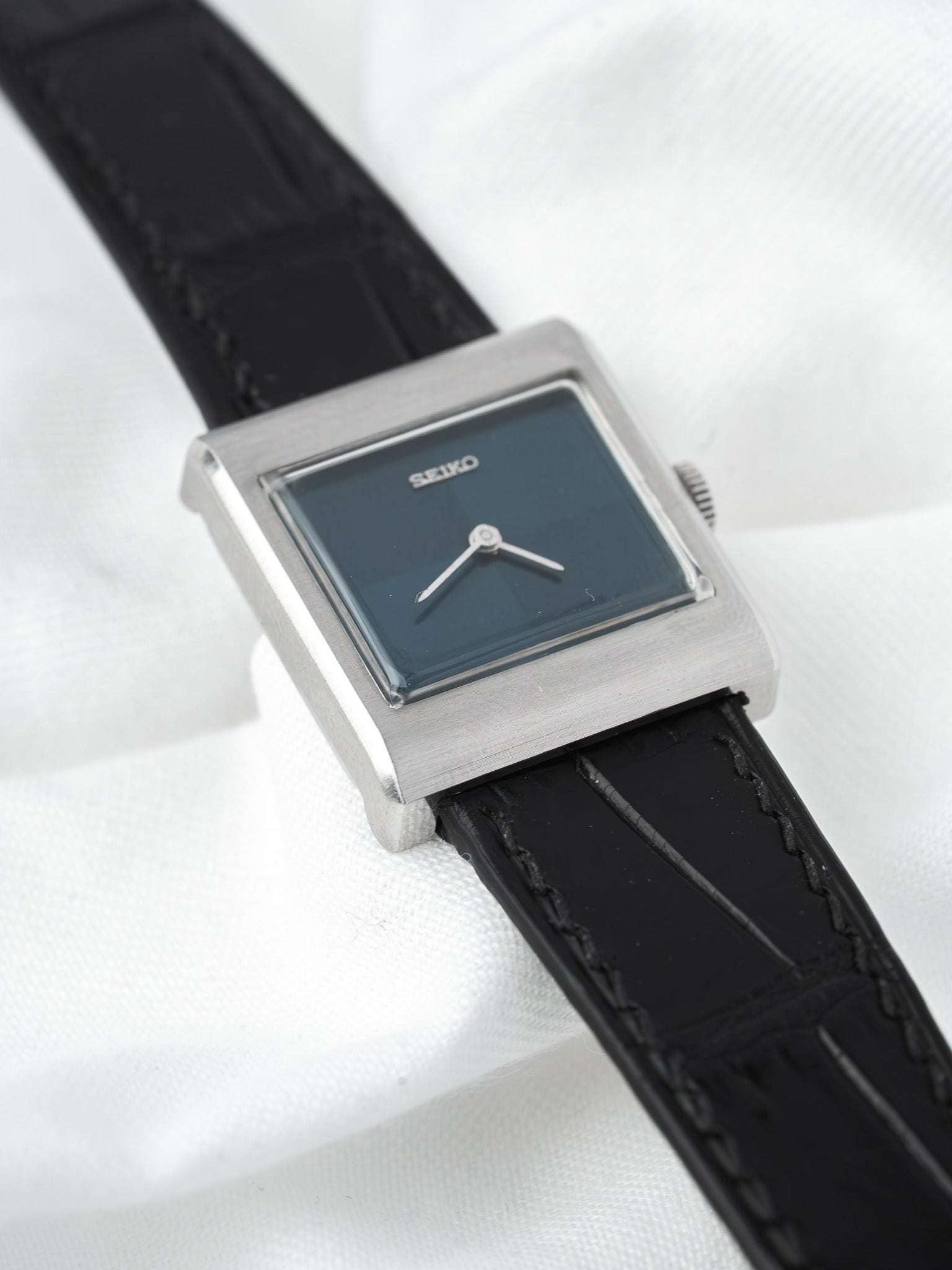 Seiko vintage watch with square silver case, dark dial, black leather strap