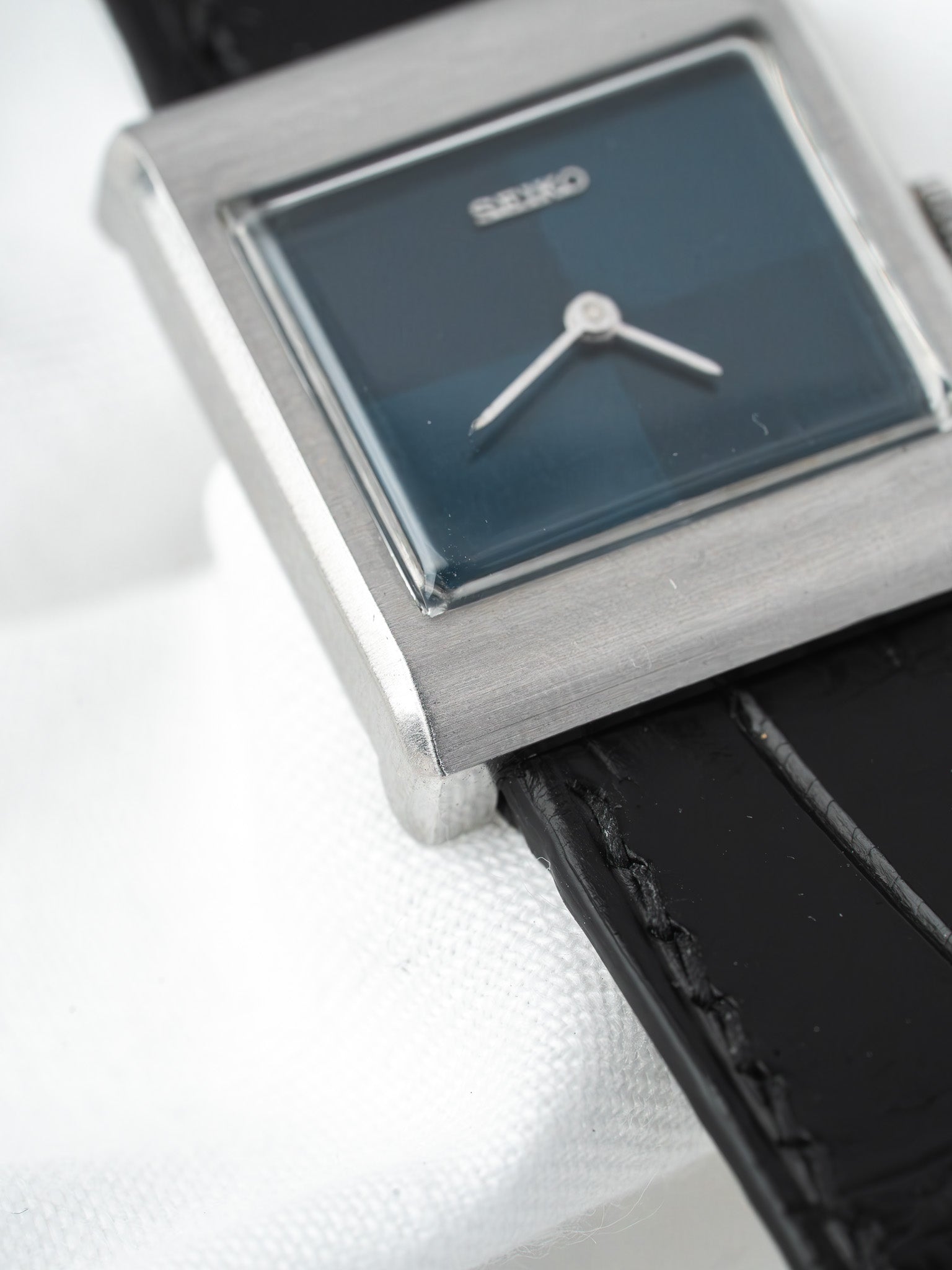 Seiko vintage watch with square silver case and black leather strap