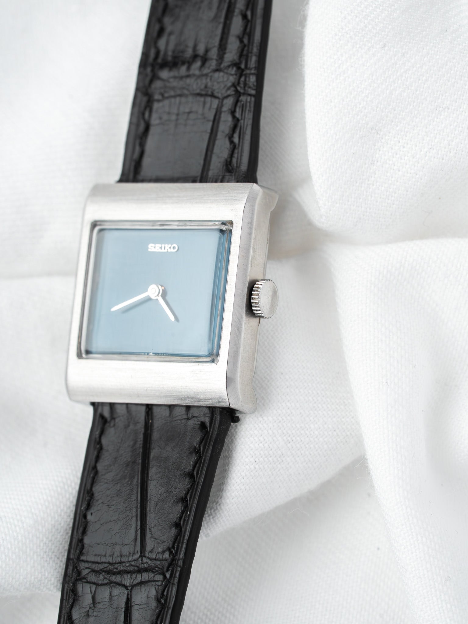 Seiko vintage watch with square silver case, light blue dial, black leather strap