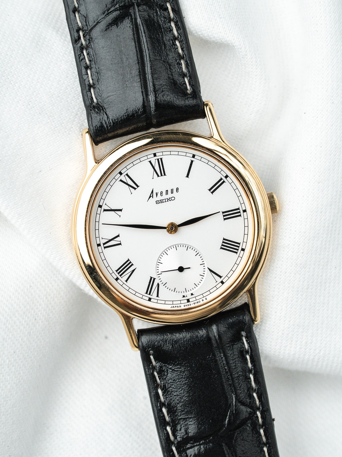 Montre Seiko Avenue vintage, boîtier doré, cadran blanc et bracelet cuir noir