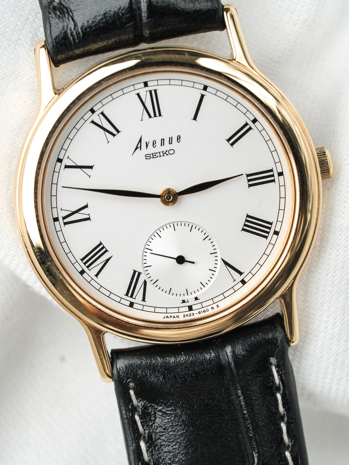 Montre Seiko Avenue vintage, boîtier doré, cadran blanc et bracelet en cuir noir