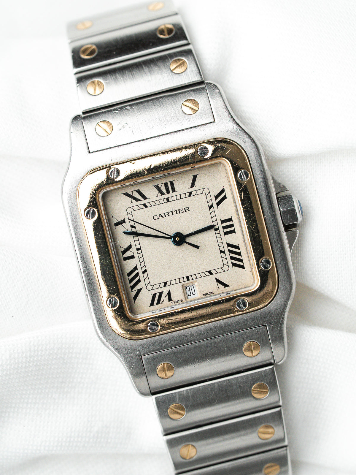 Montre Cartier vintage en acier, boîtier carré et cadran blanc sur fond blanc