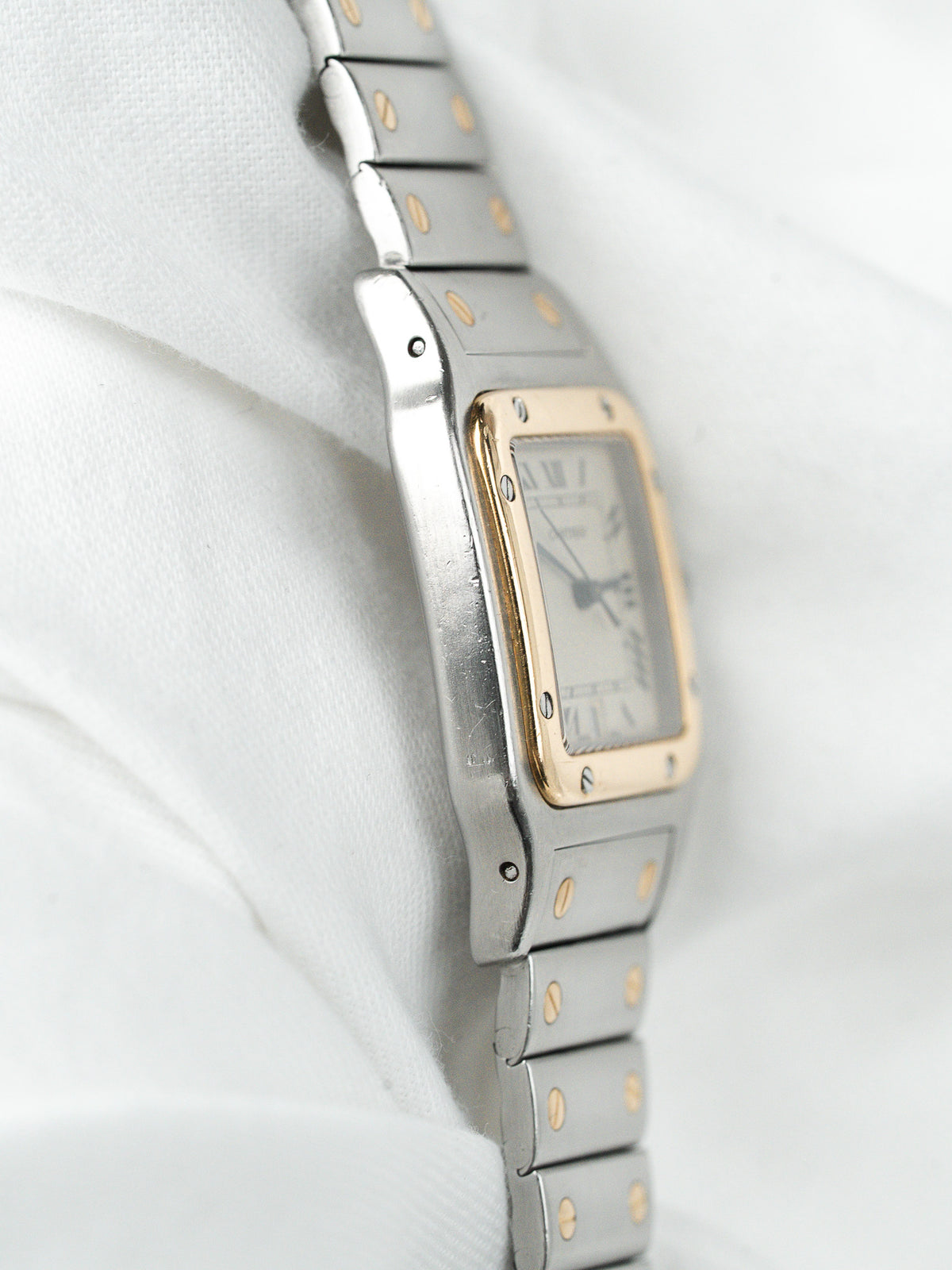 Montre Cartier vintage, boîtier rectangulaire et bracelet en acier et or, fond blanc
