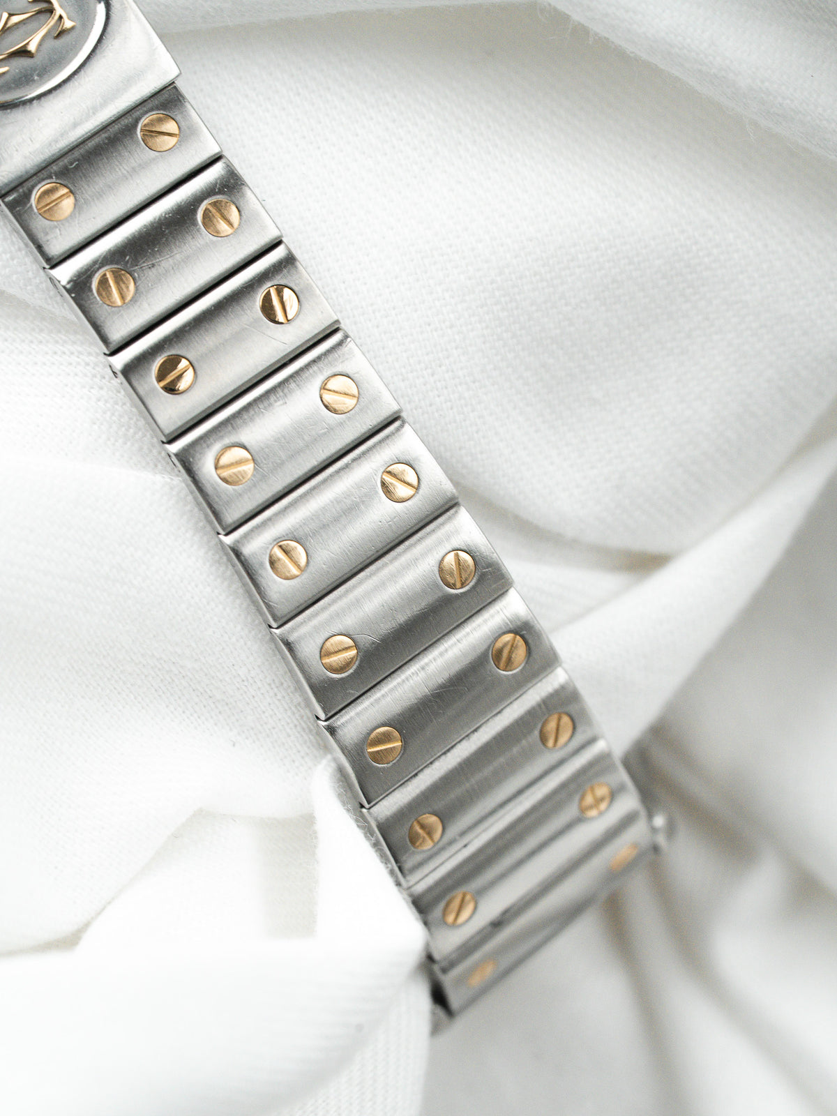 Bracelet de montre Rolex en acier et or avec vis apparentes sur fond blanc