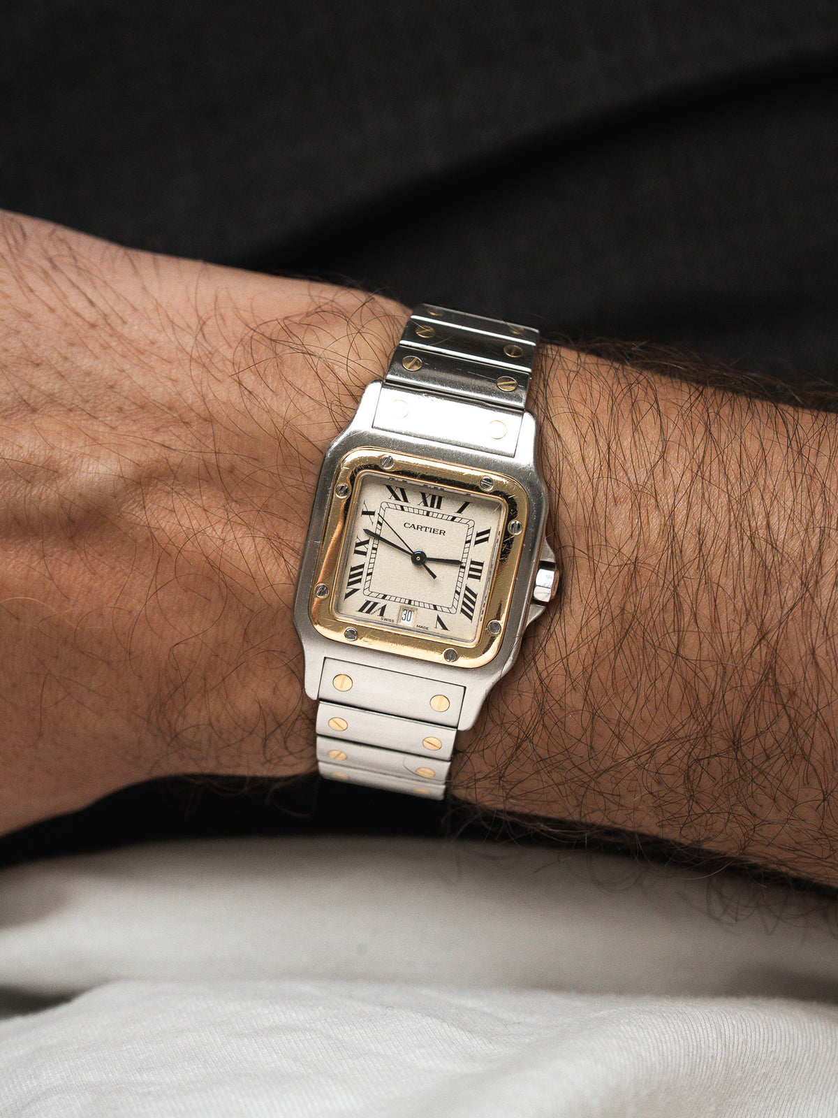 Montre Cartier vintage en acier et or, boîtier carré, portée au poignet