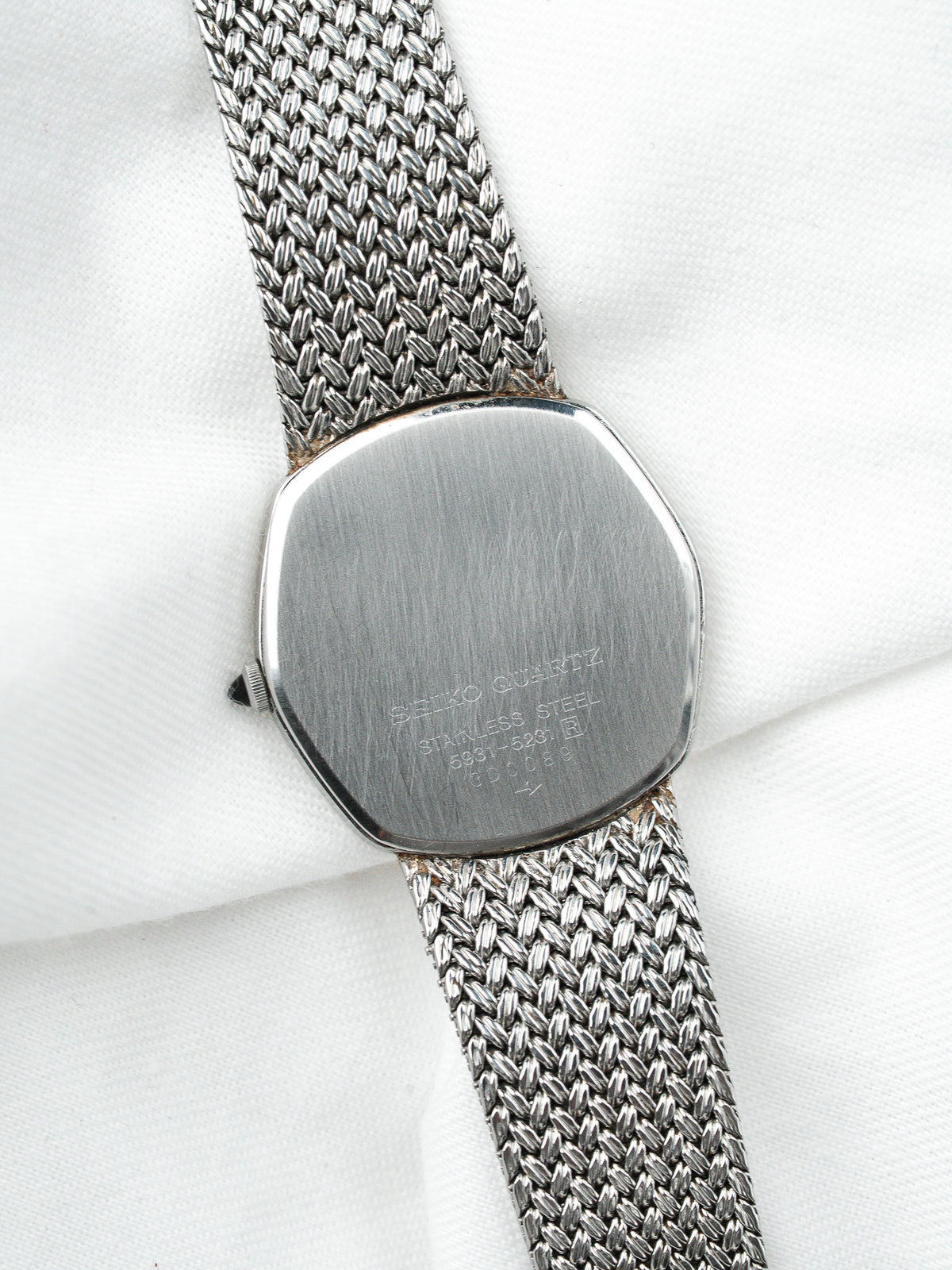 Dos d'une montre Seiko Quartz vintage en acier avec bracelet maille milanaise