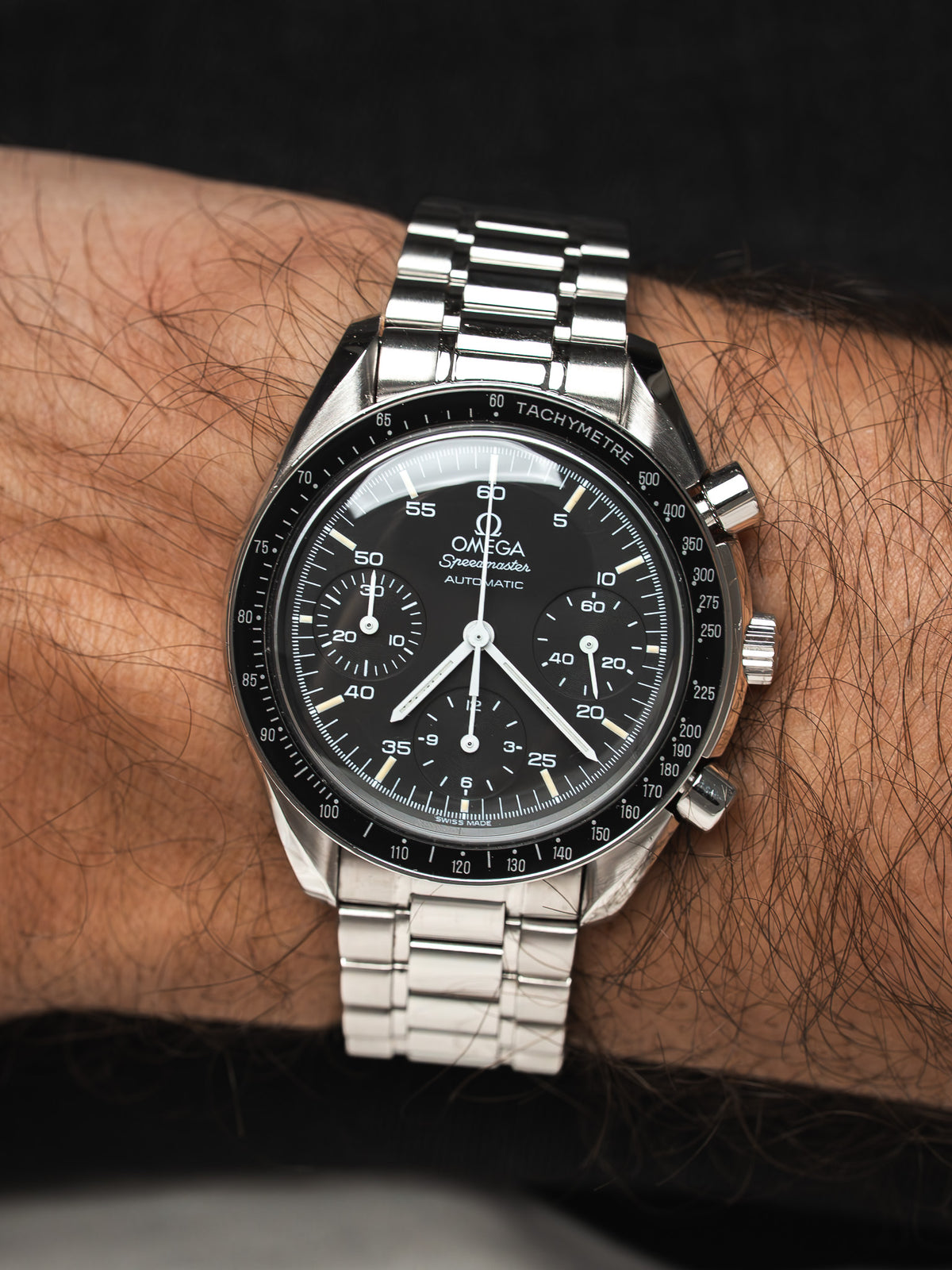 Montre Omega Speedmaster en acier avec cadran noir, portée au poignet