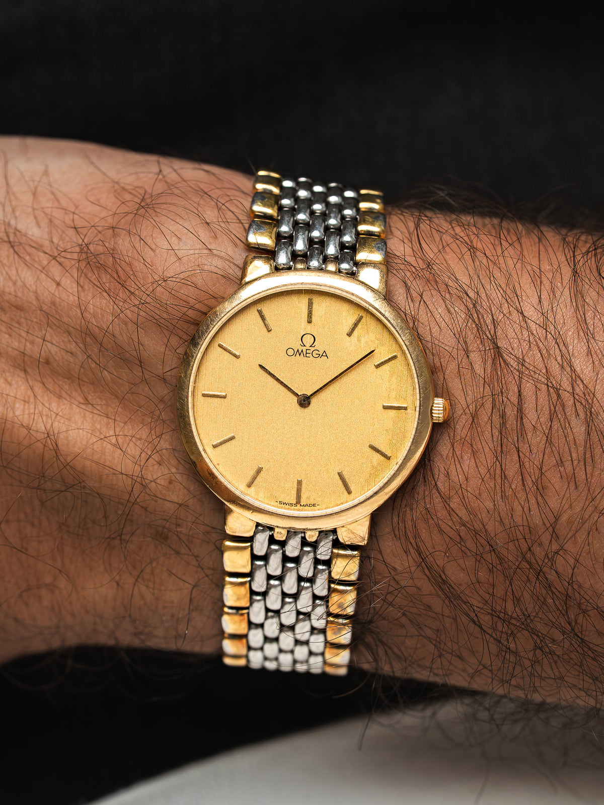 Montre Omega vintage en or et acier, cadran doré, portée au poignet