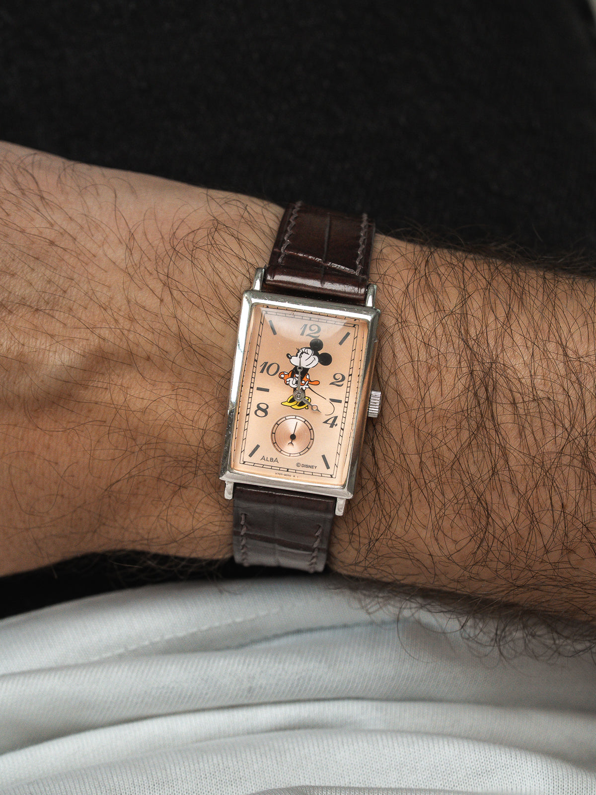 Montre vintage rectangulaire avec cadran Mickey Mouse et bracelet en cuir marron.