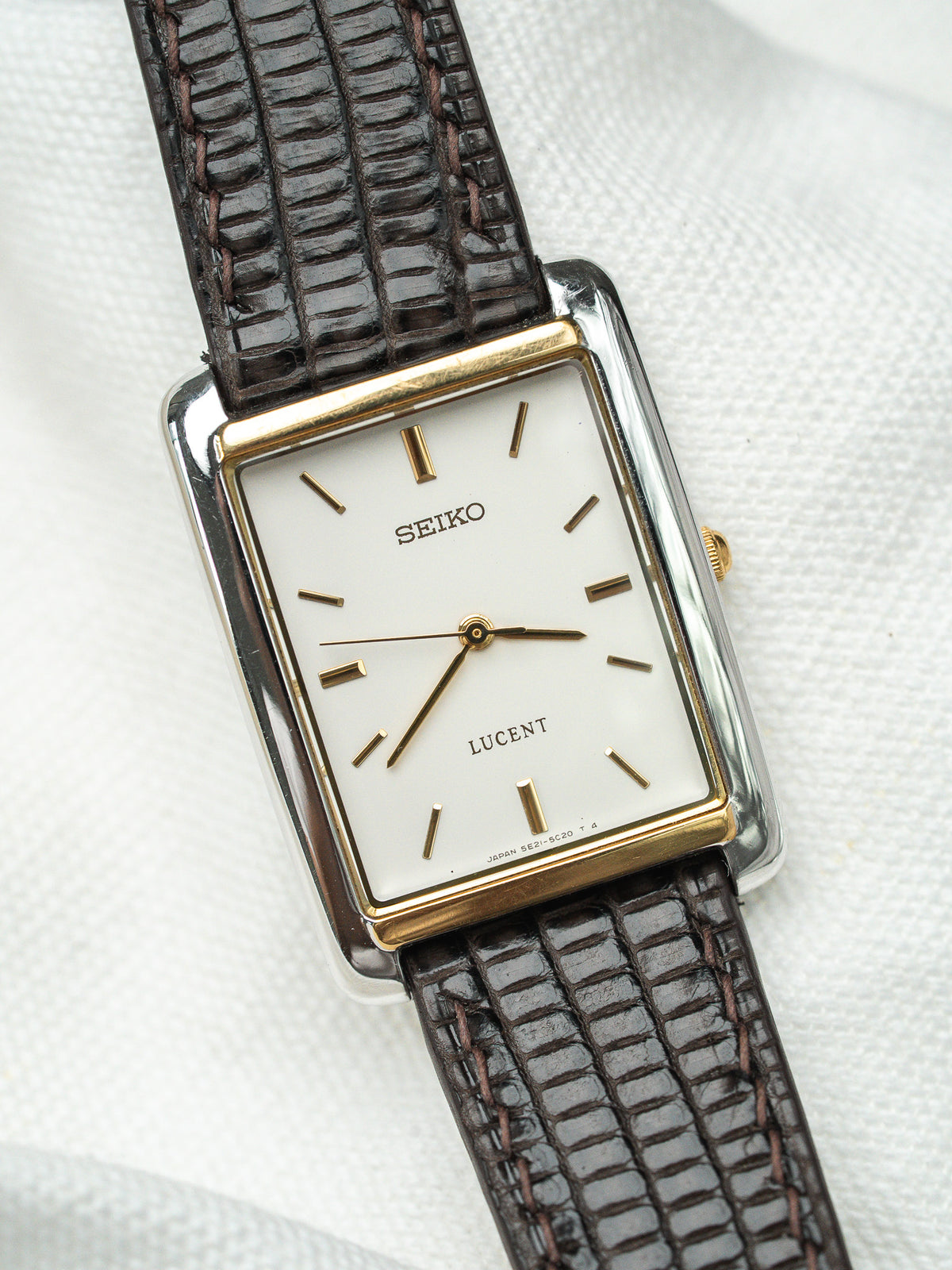 Montre Seiko Lucent vintage au cadran blanc rectangulaire et bracelet en cuir marron.
