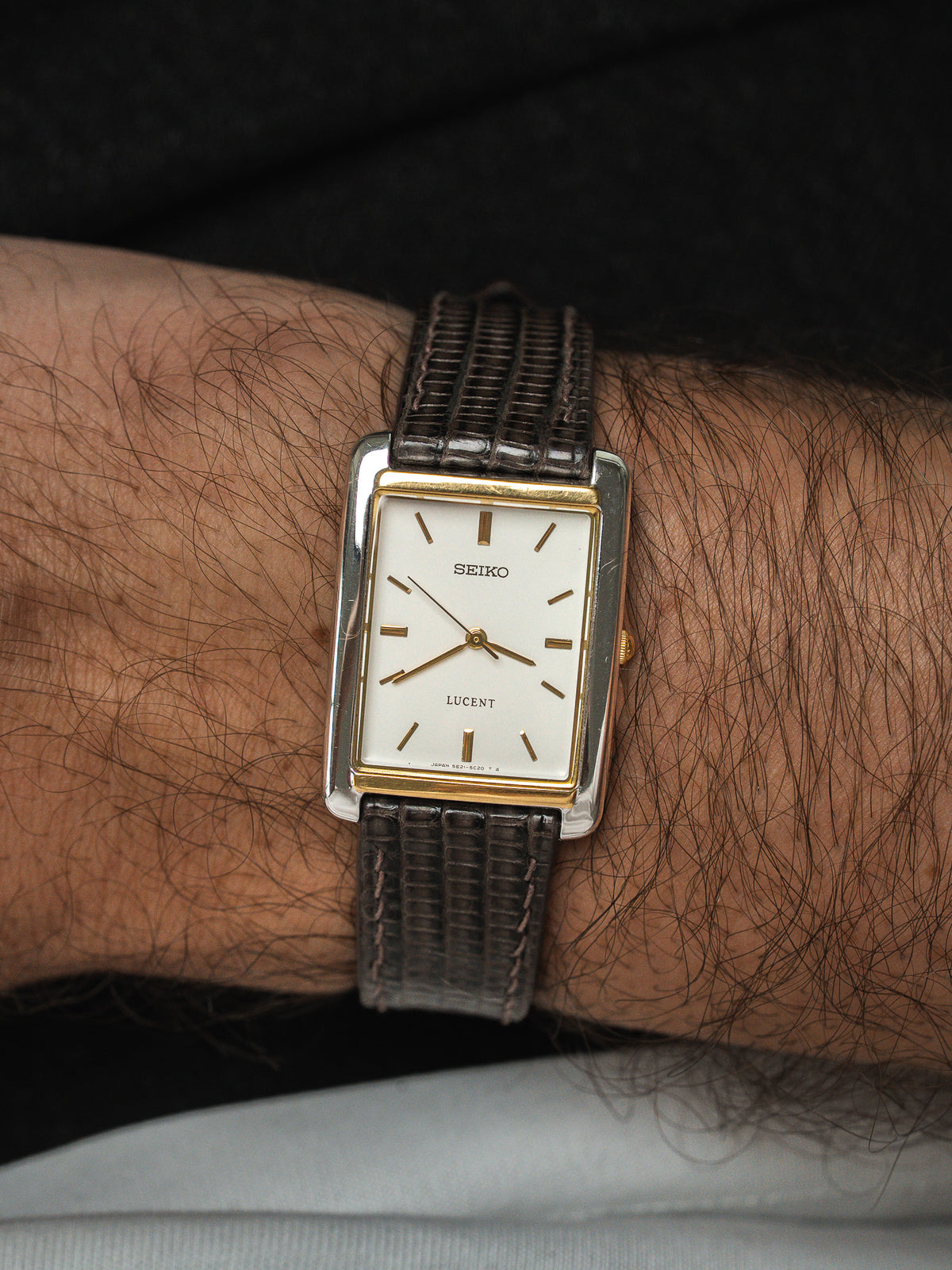 Montre Seiko Lucent vintage au boîtier rectangulaire doré et bracelet en cuir marron.