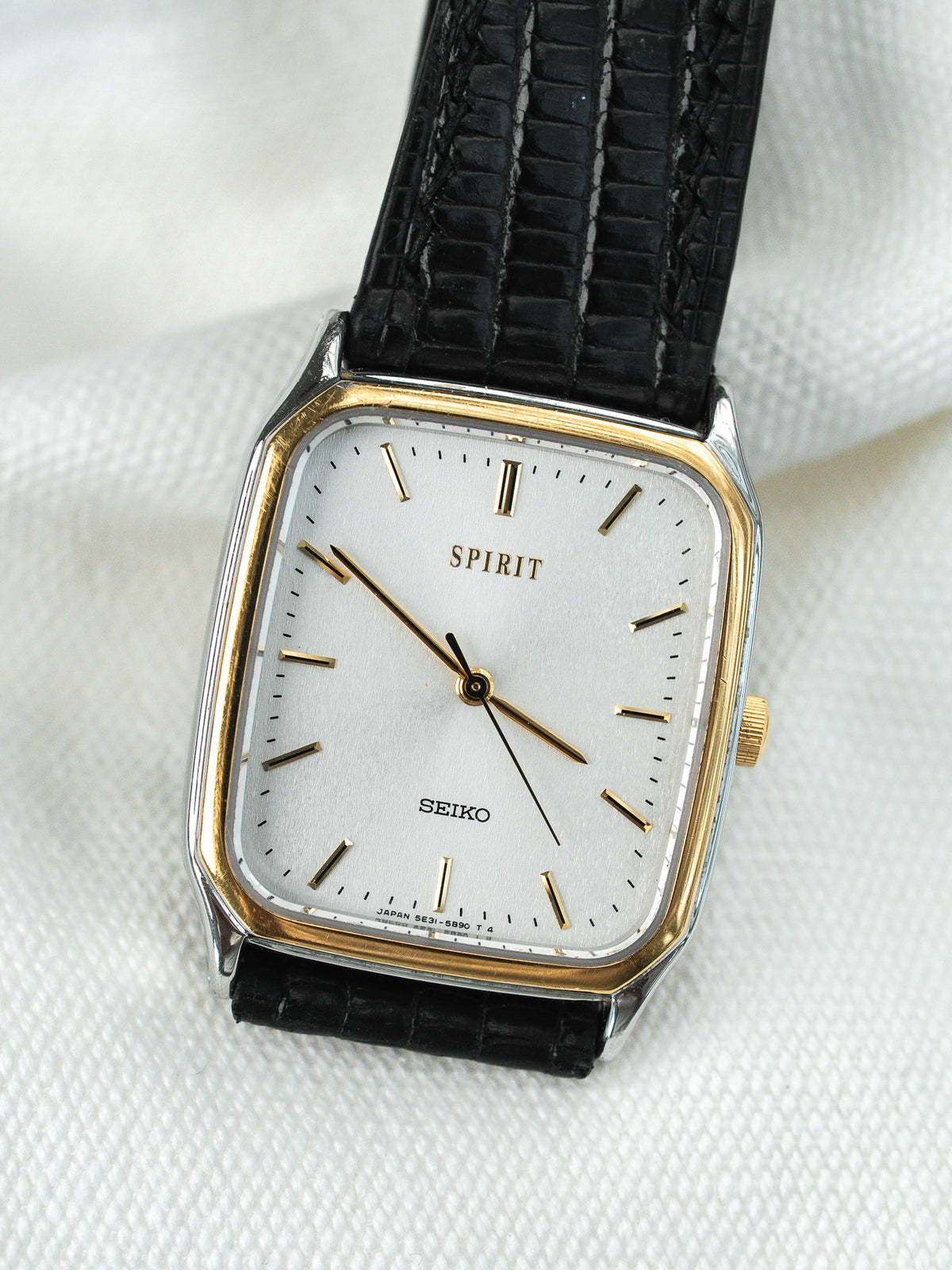 Lunette dorée à pans coupés en gros plan - Montre Seiko Spirit 5E31-5B50 - Atelier Victor