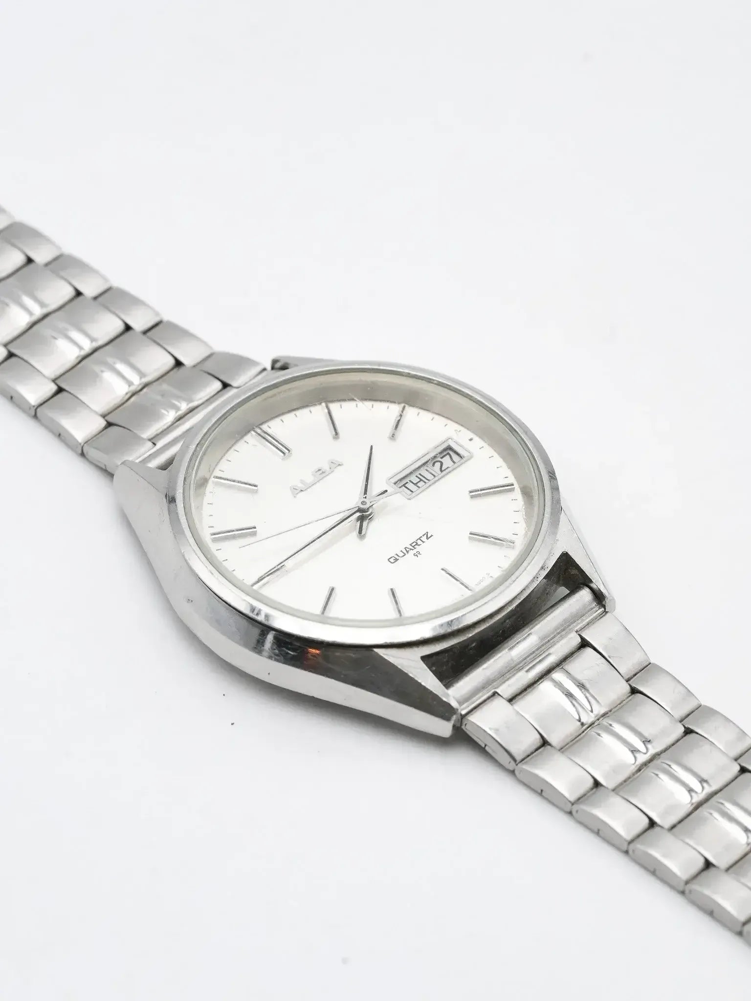 Alba vintage quartz watch with white dial, day-date window, stainless steel bracelet on white background
