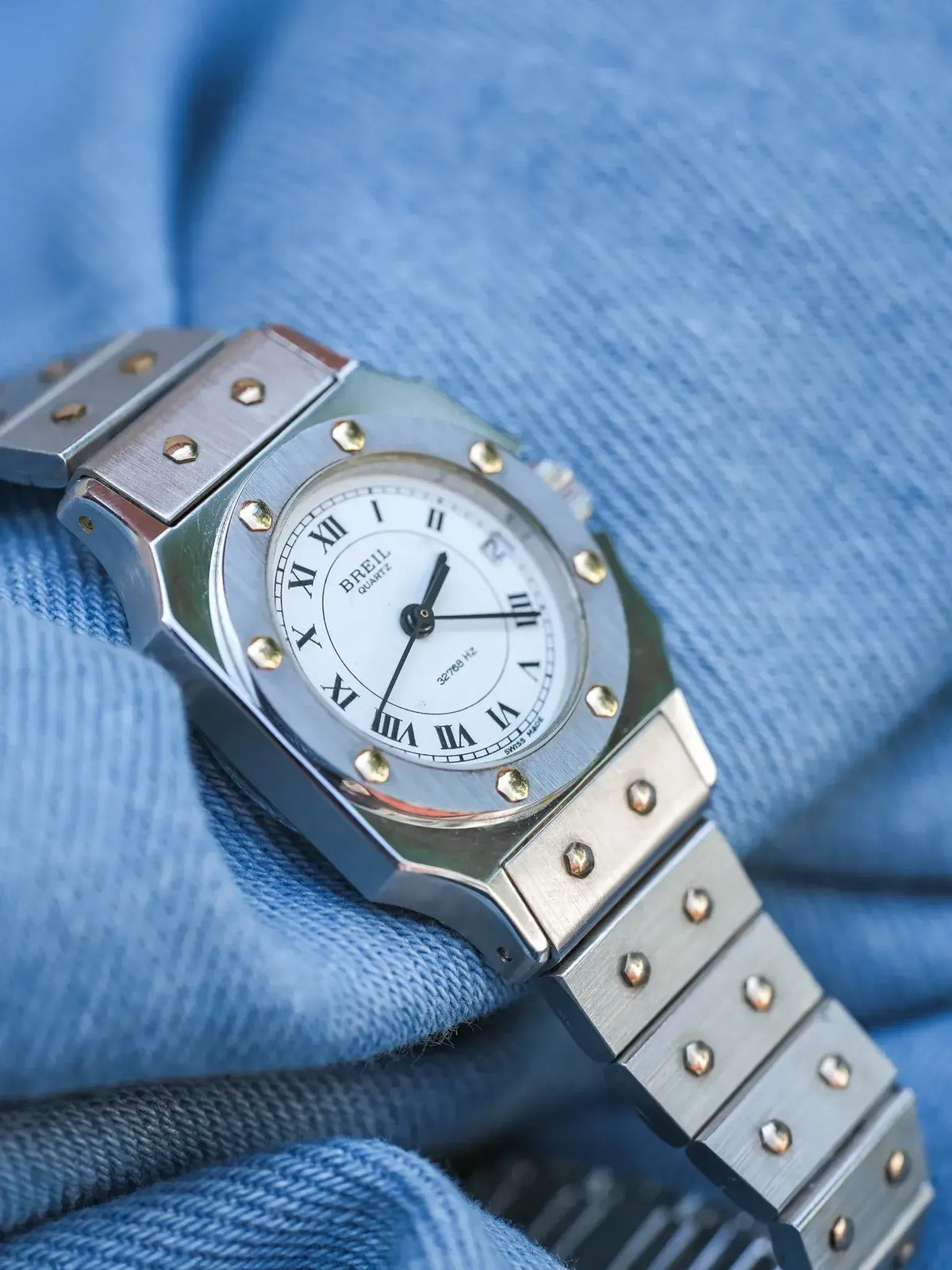Breil quartz watch with white dial, Roman numerals, steel case and bracelet on blue fabric