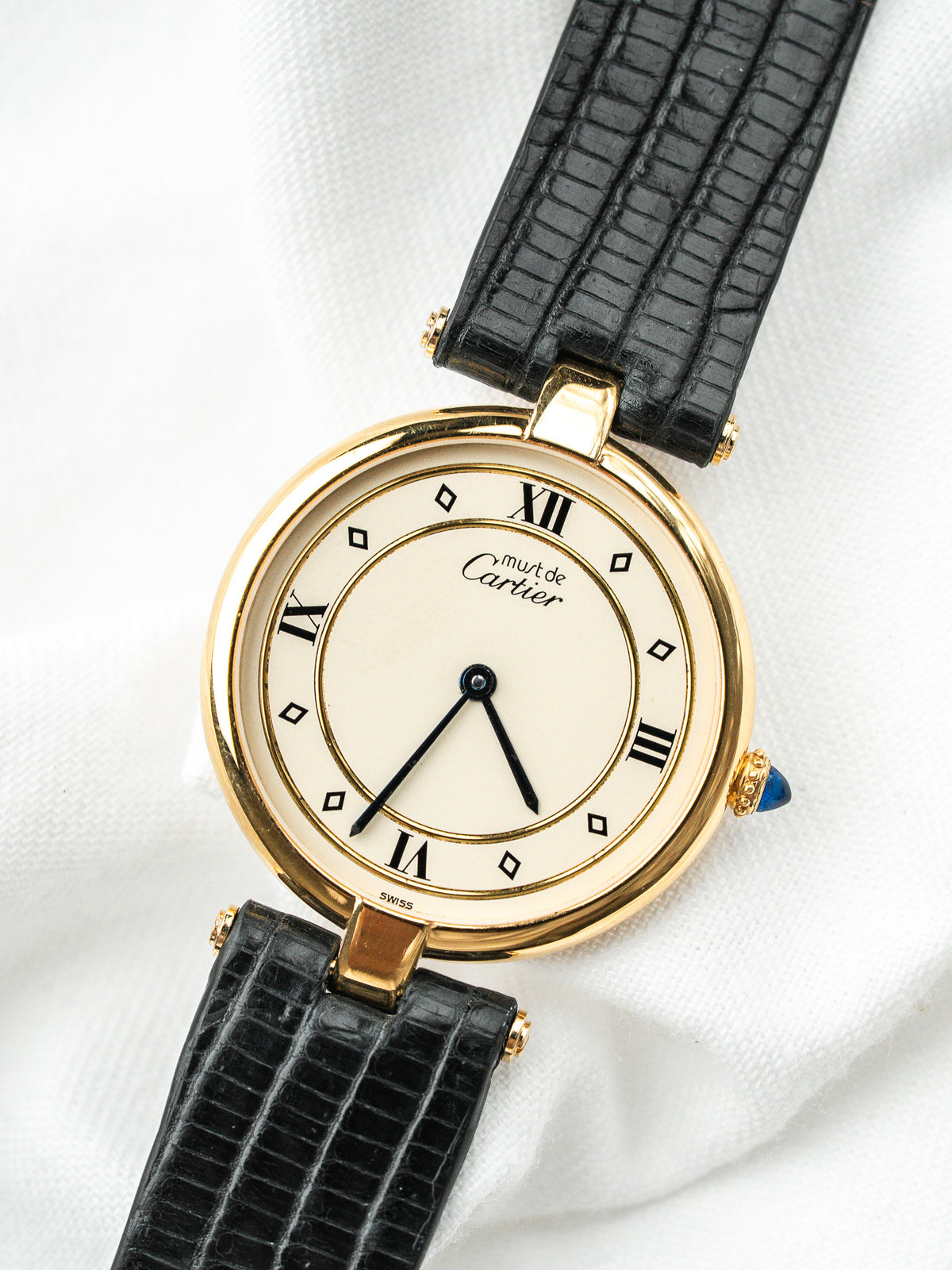 Montre Cartier Must de Cartier vintage, boîtier rond doré, cadran crème et bracelet cuir noir