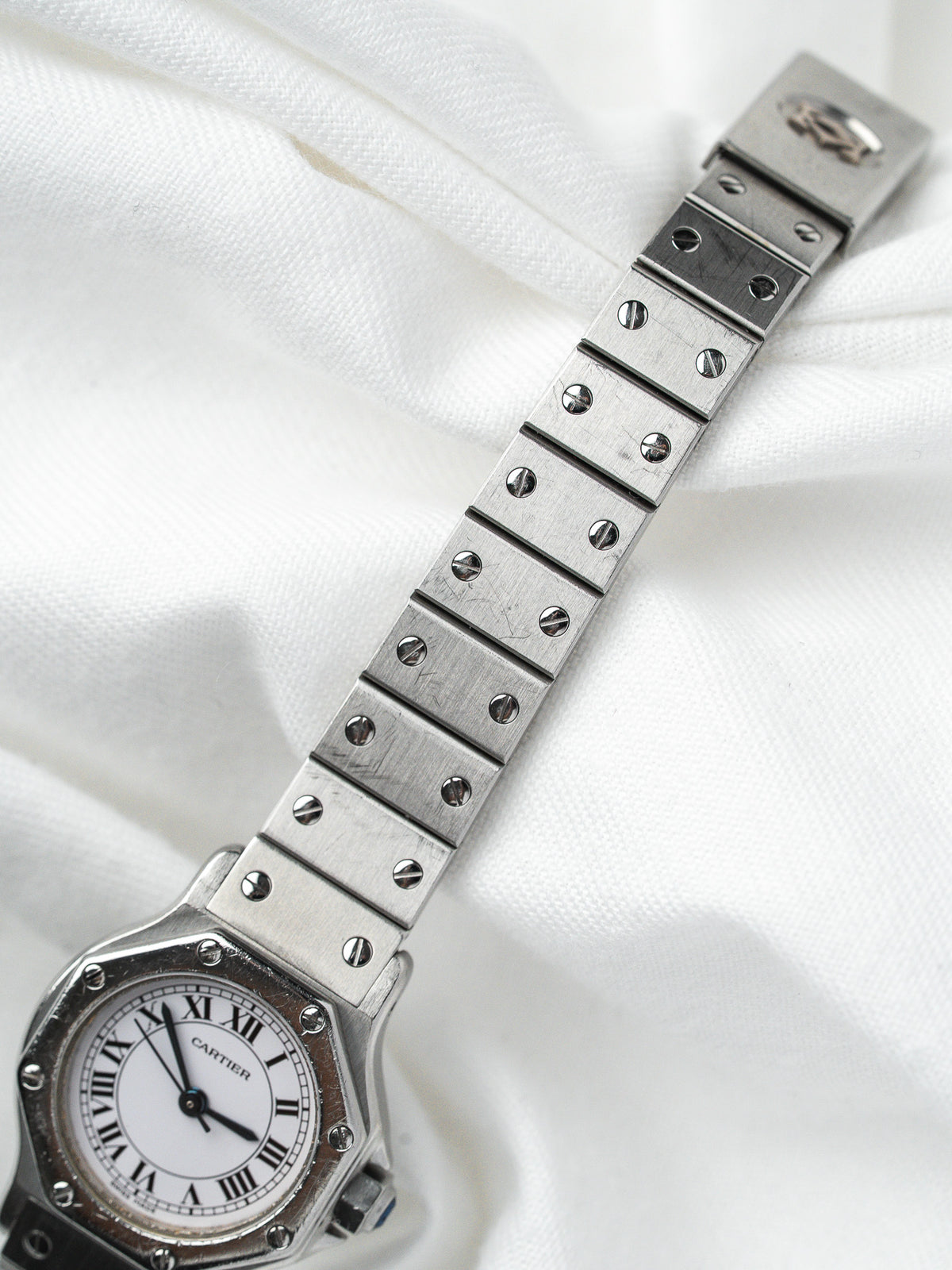 Montre Cartier vintage en acier avec bracelet à vis sur fond de tissu blanc