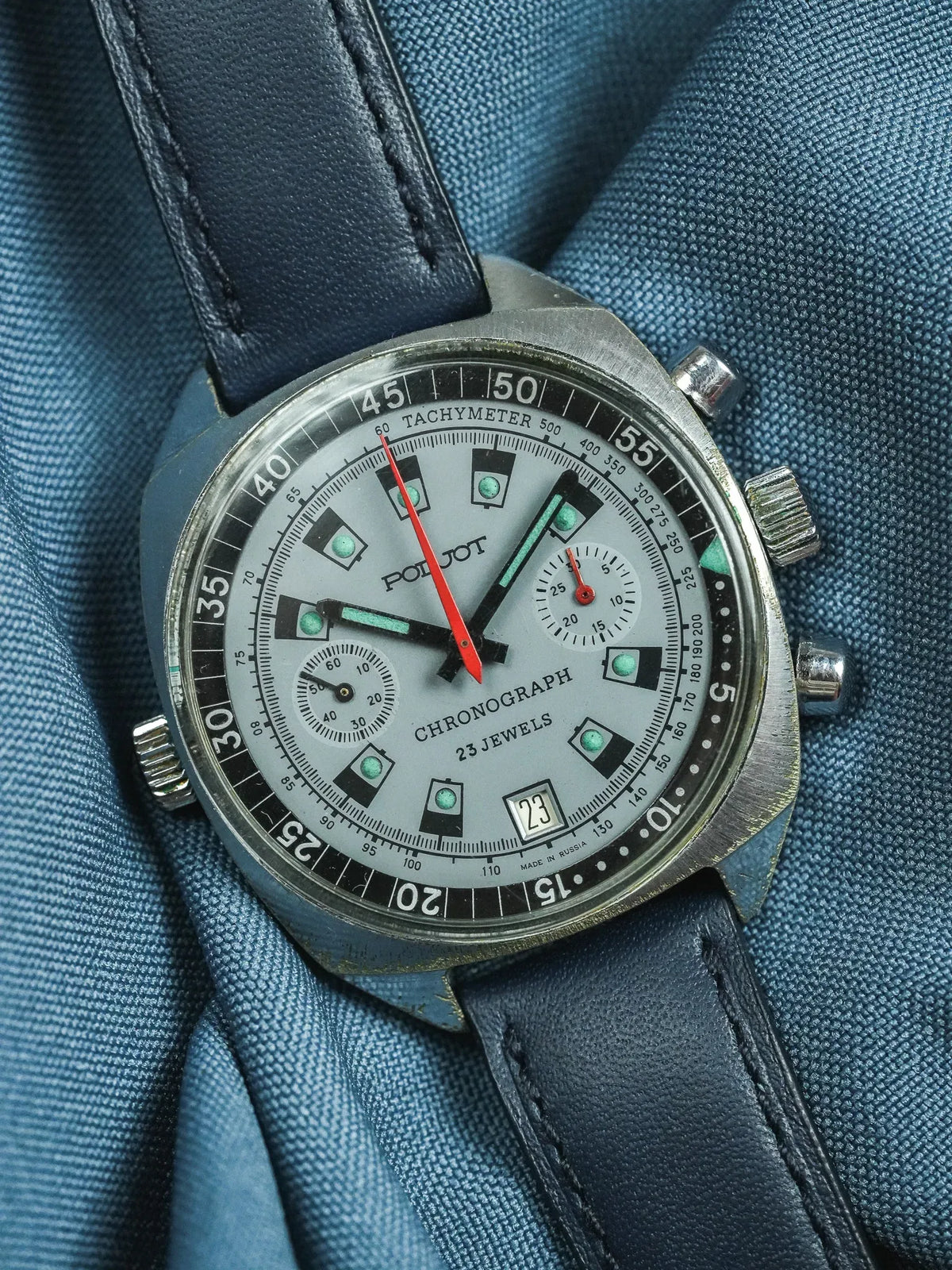 Vintage Poljot chronograph watch with silver dial, black bezel, and blue leather strap