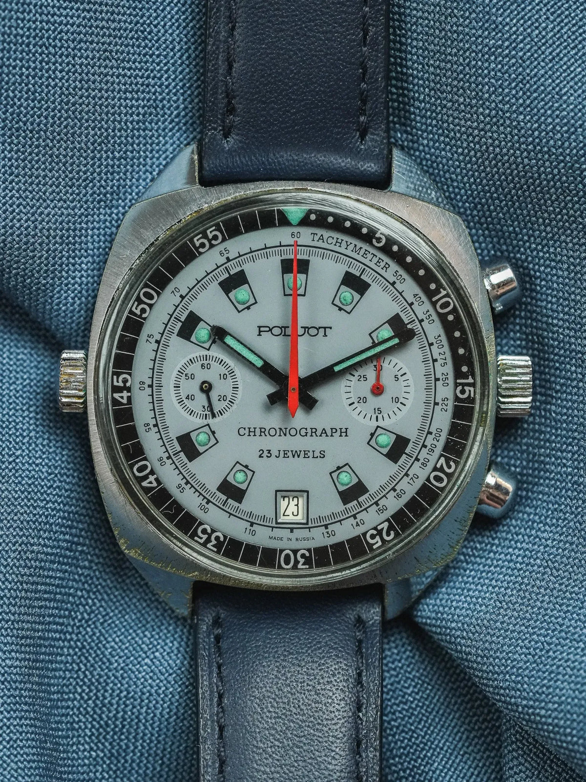 Poljot vintage chronograph watch with silver dial, black bezel, and blue leather strap