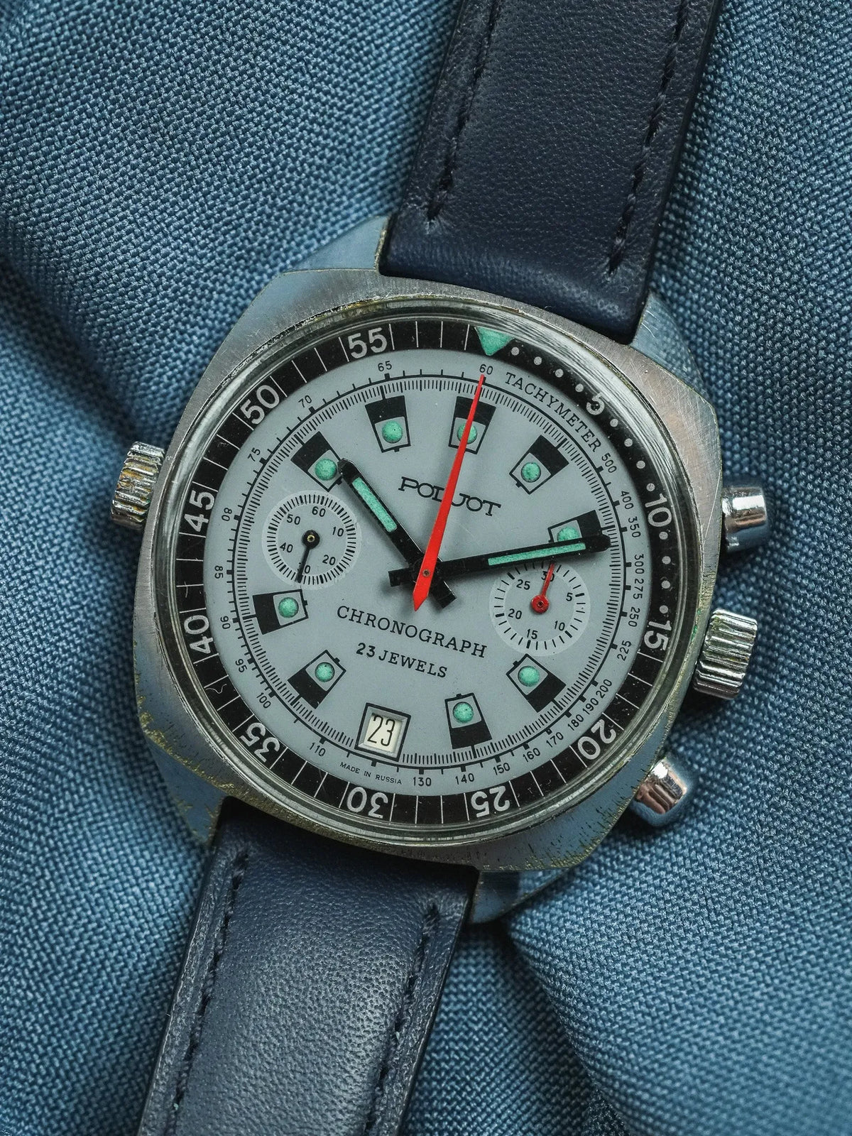 Vintage Poljot chronograph watch with silver dial, black tachymeter, and blue leather strap
