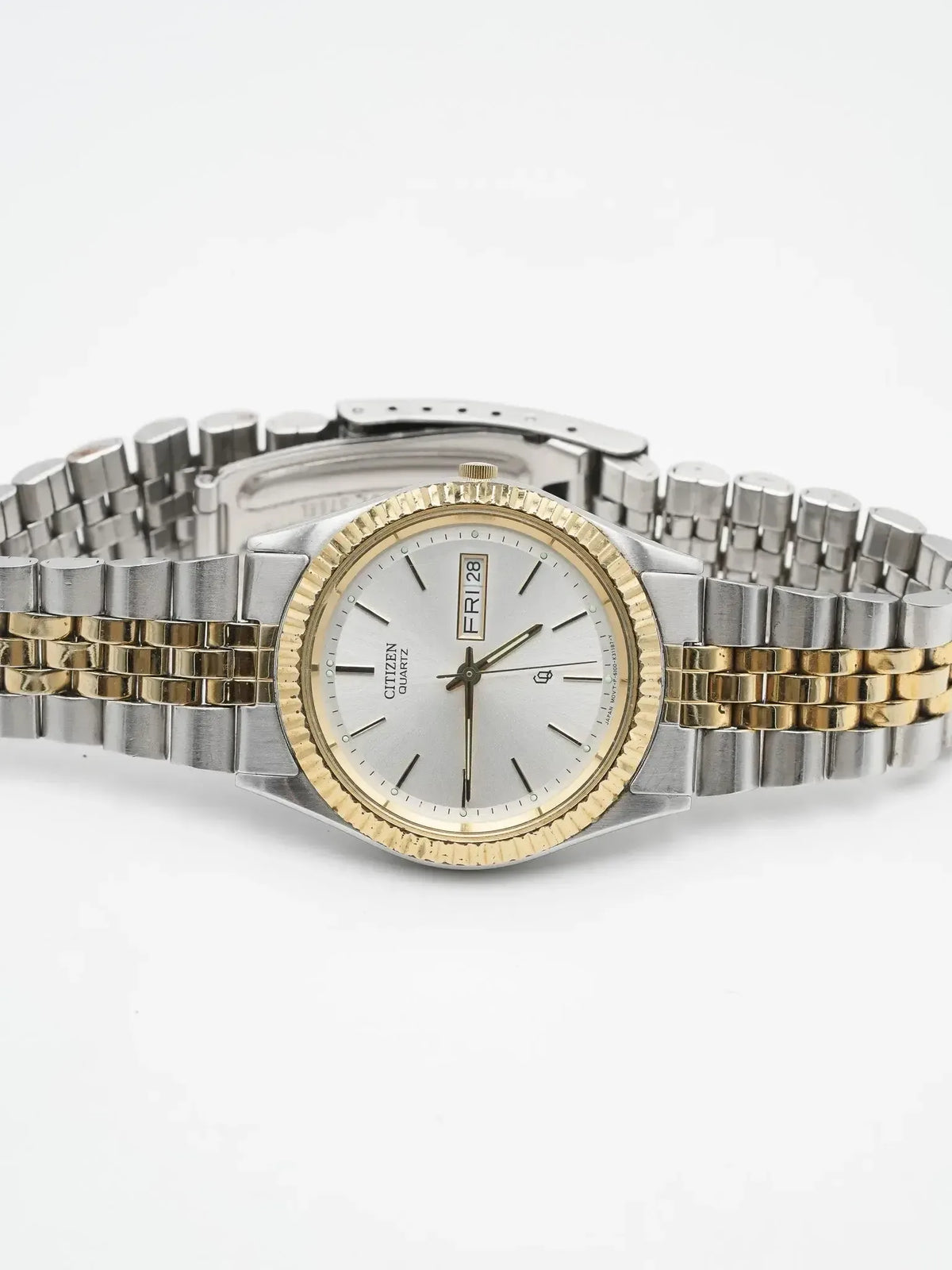 Citizen Quartz vintage watch with silver dial, gold bezel, two-tone steel bracelet on white background