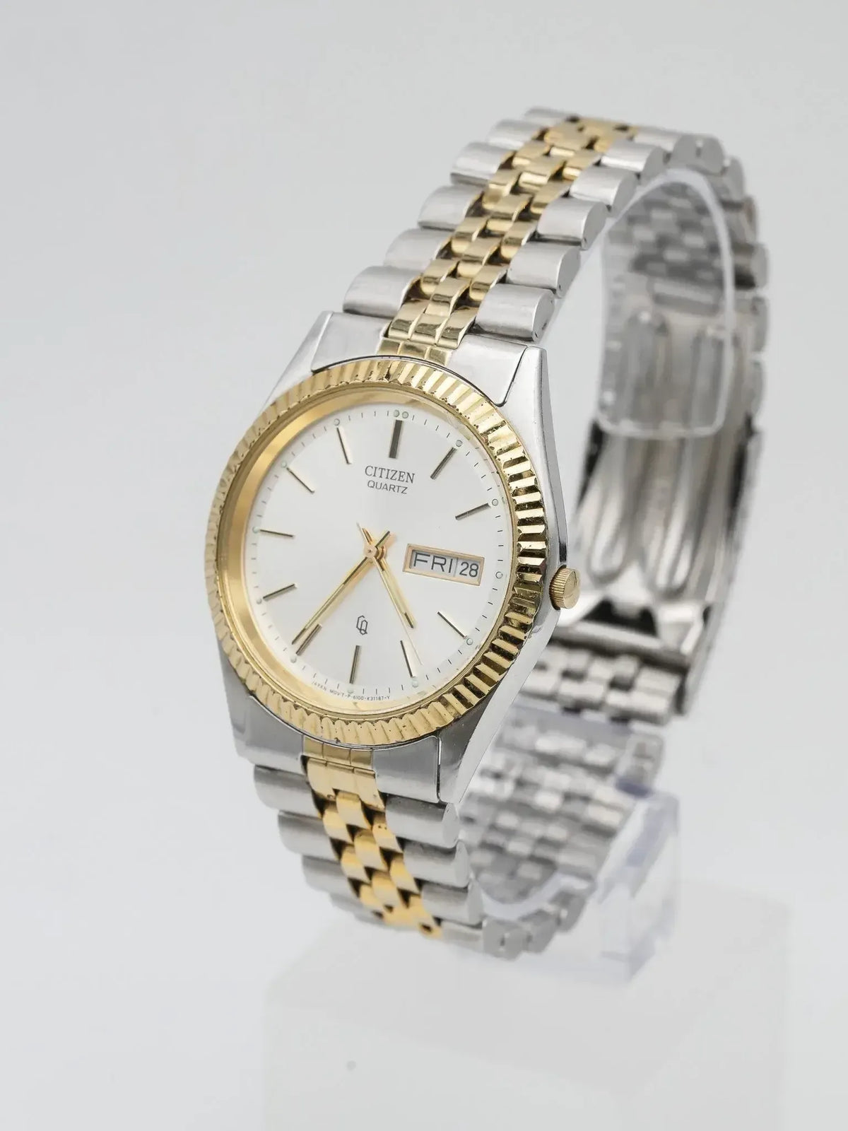 Citizen quartz watch with two-tone bracelet, white dial, day-date display on neutral background