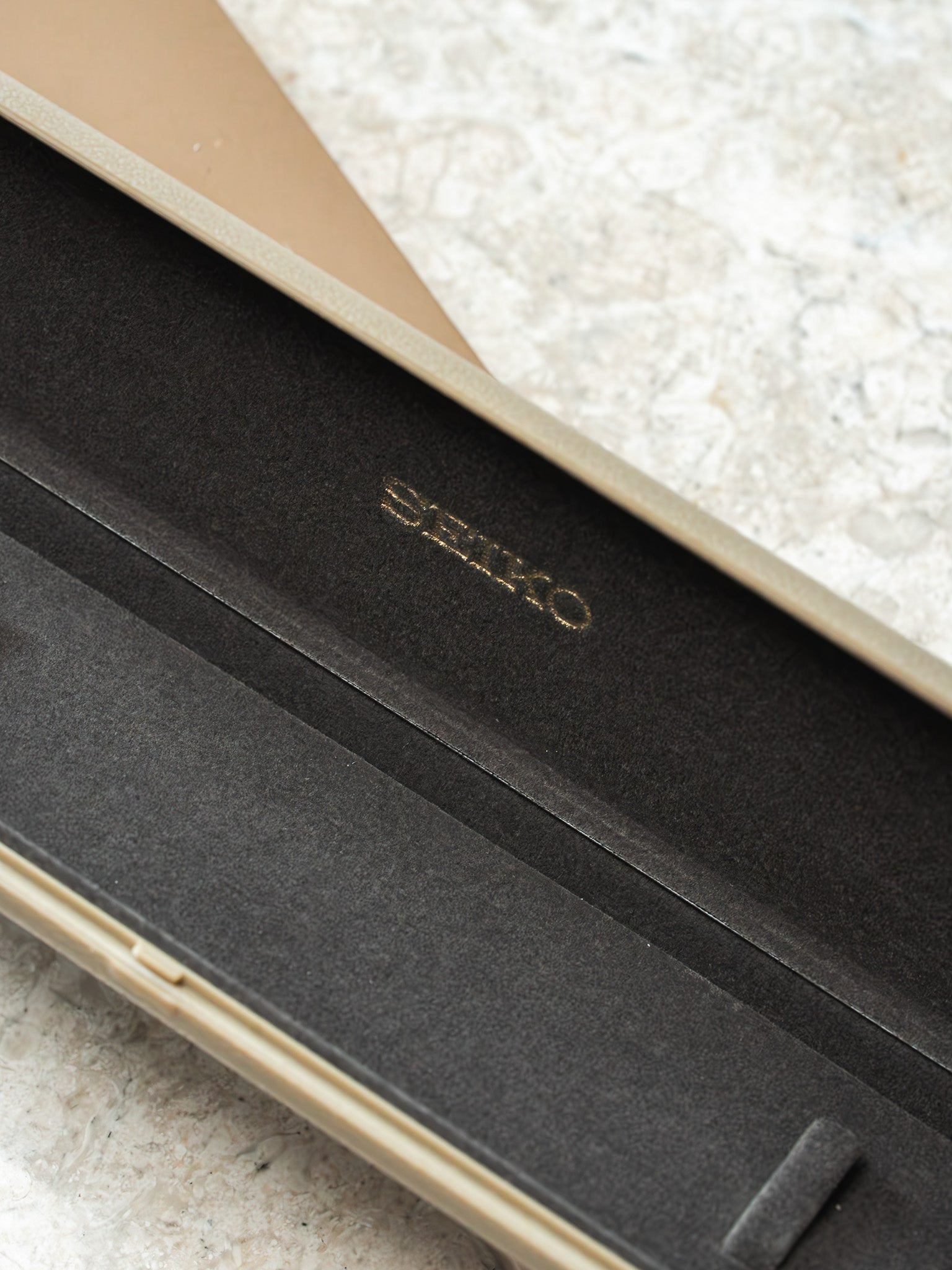 Seiko watch box interior with gold logo on black velvet lining