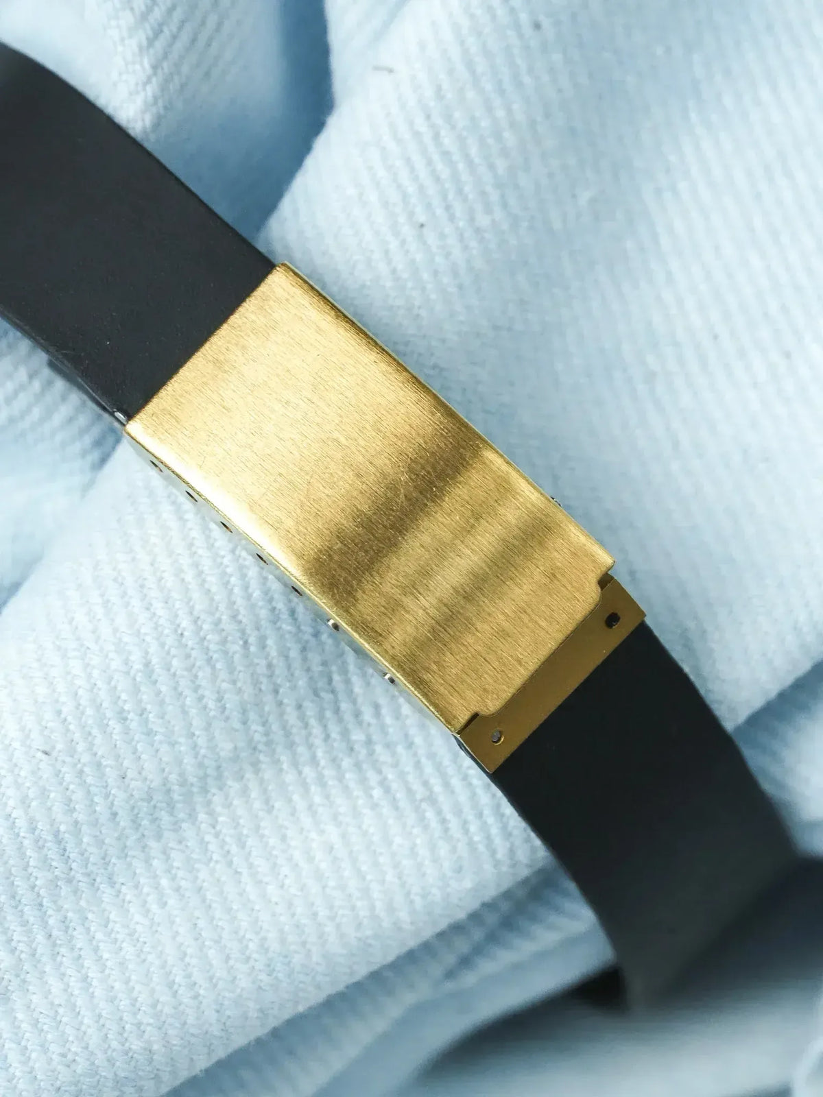 Cartier Tank vintage bracelet with gold-plated buckle and black leather strap on white fabric