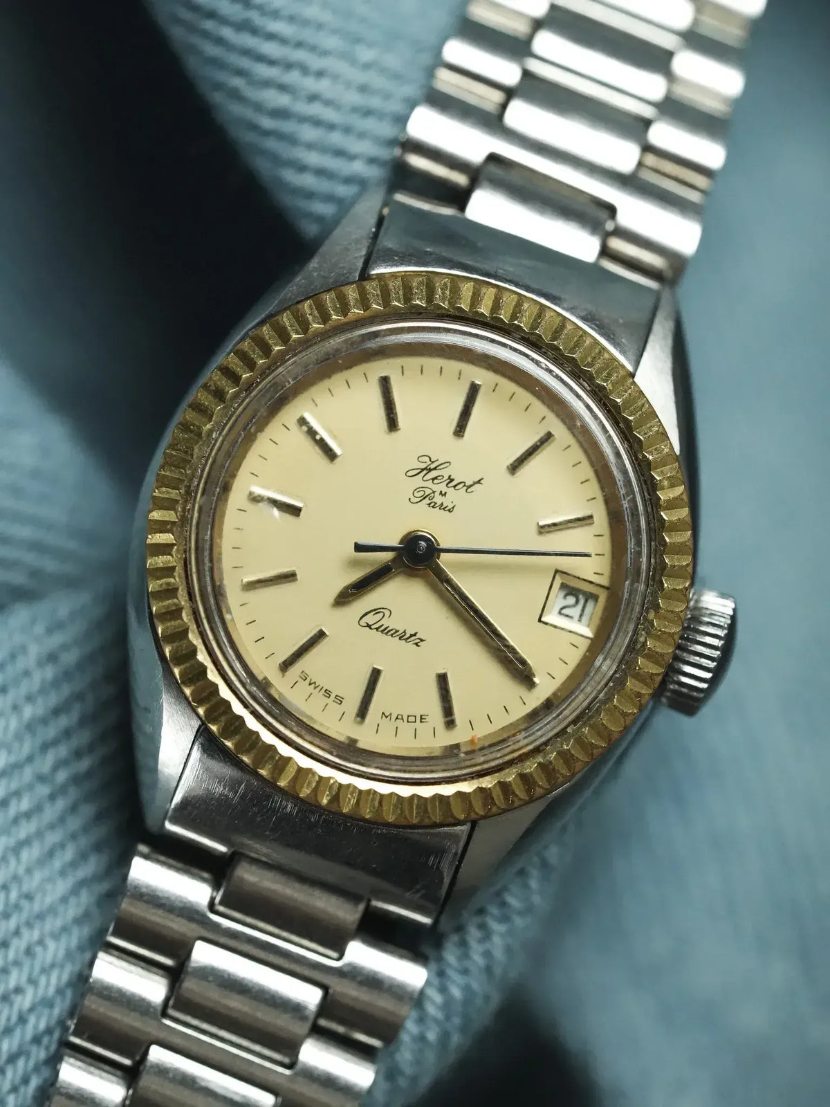 Herot Paris vintage quartz watch with cream dial, gold bezel, and steel bracelet