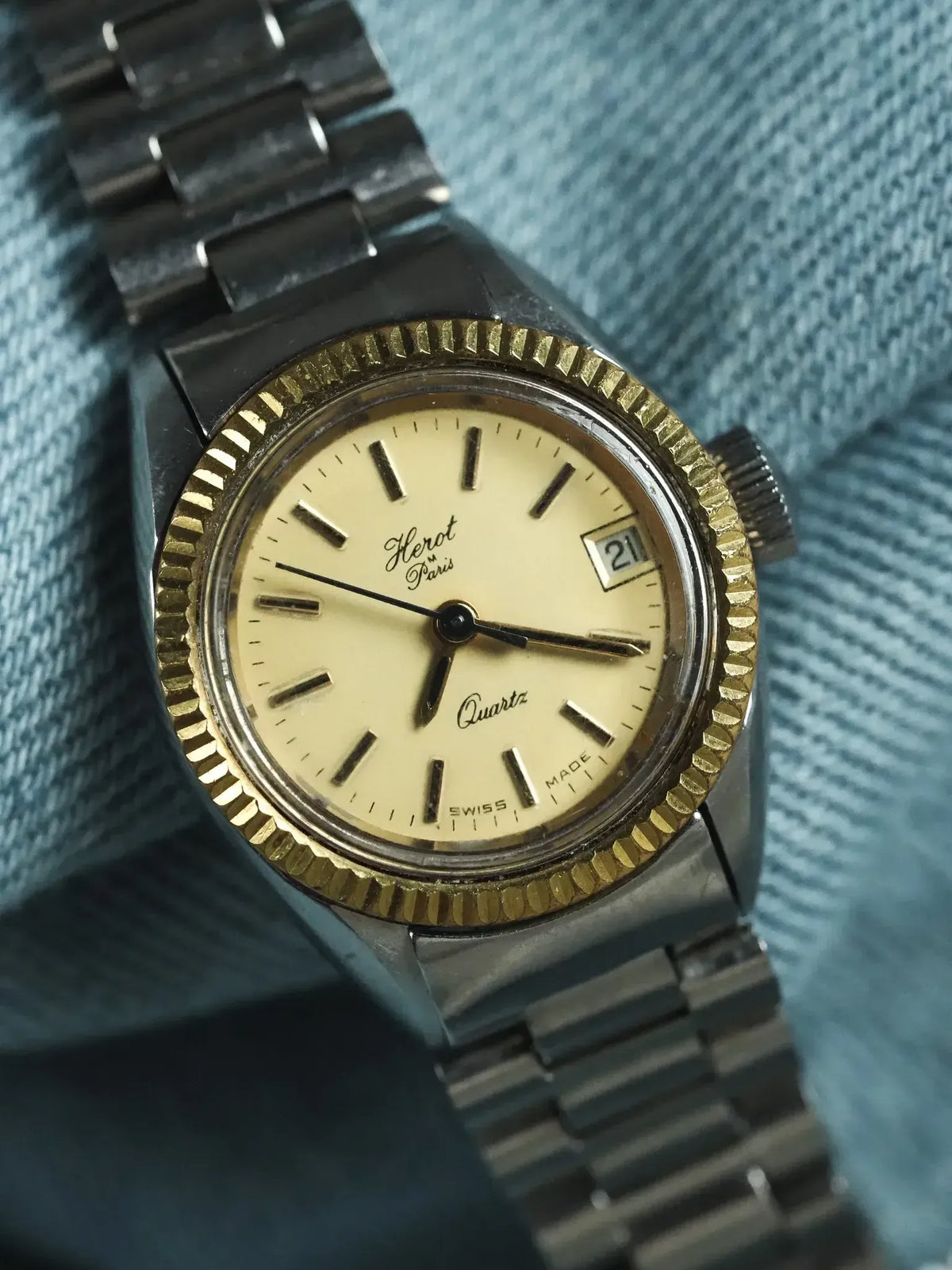 Herot Paris vintage quartz watch with cream dial, gold bezel, steel bracelet on denim