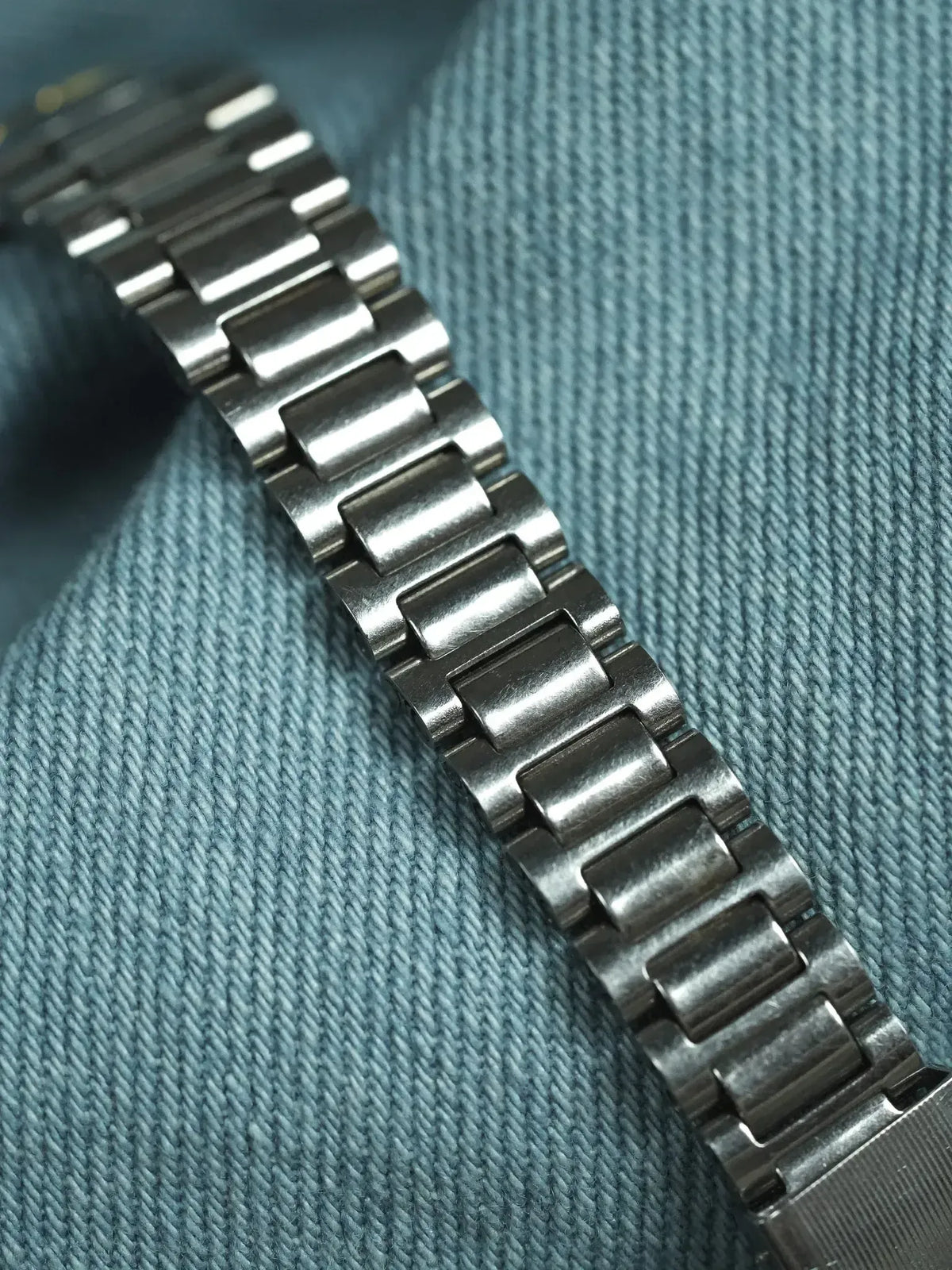 Vintage Rolex Oyster bracelet in stainless steel on denim background