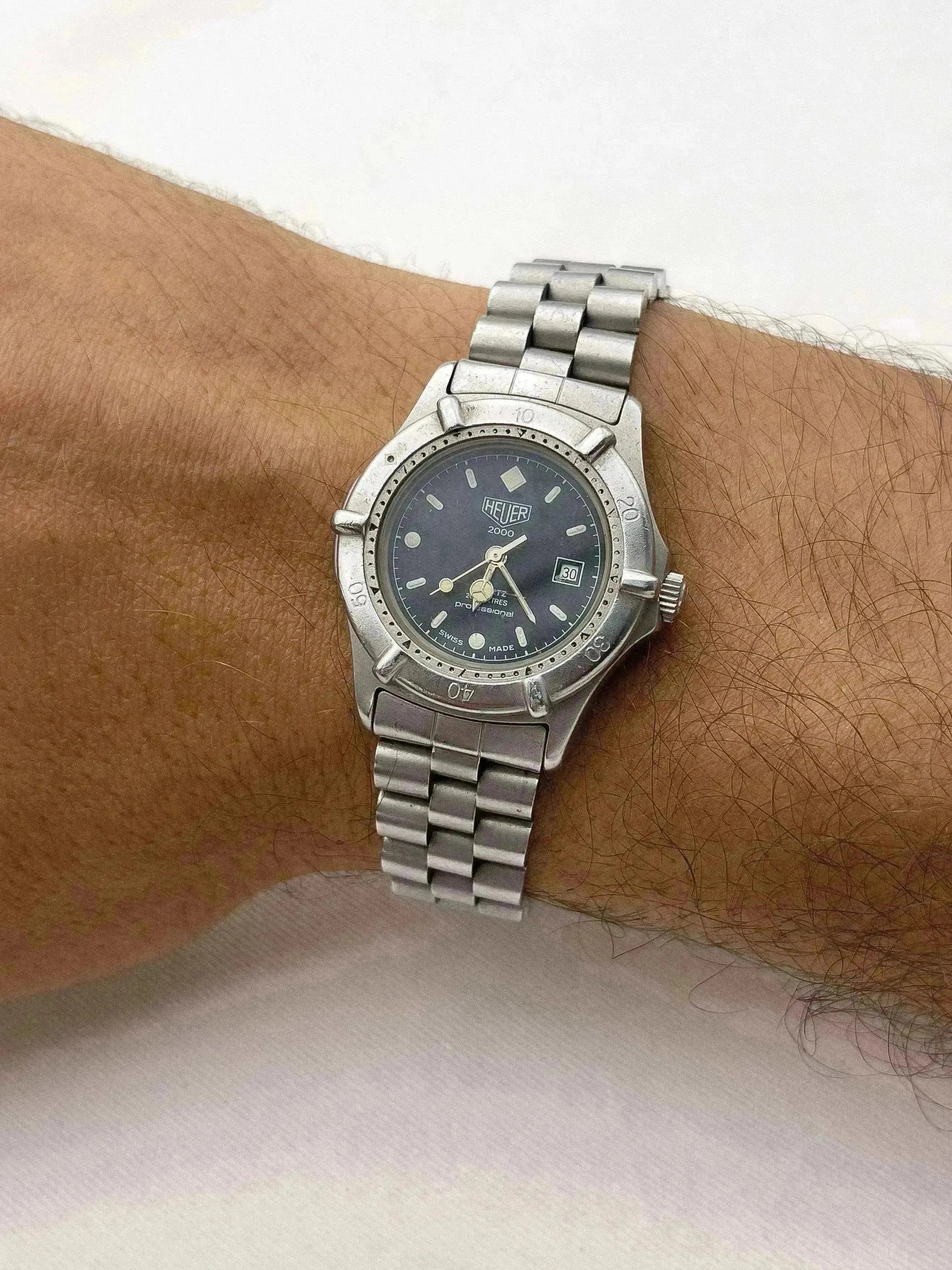 Heuer 2000 vintage watch with steel bracelet, dark dial, worn on wrist