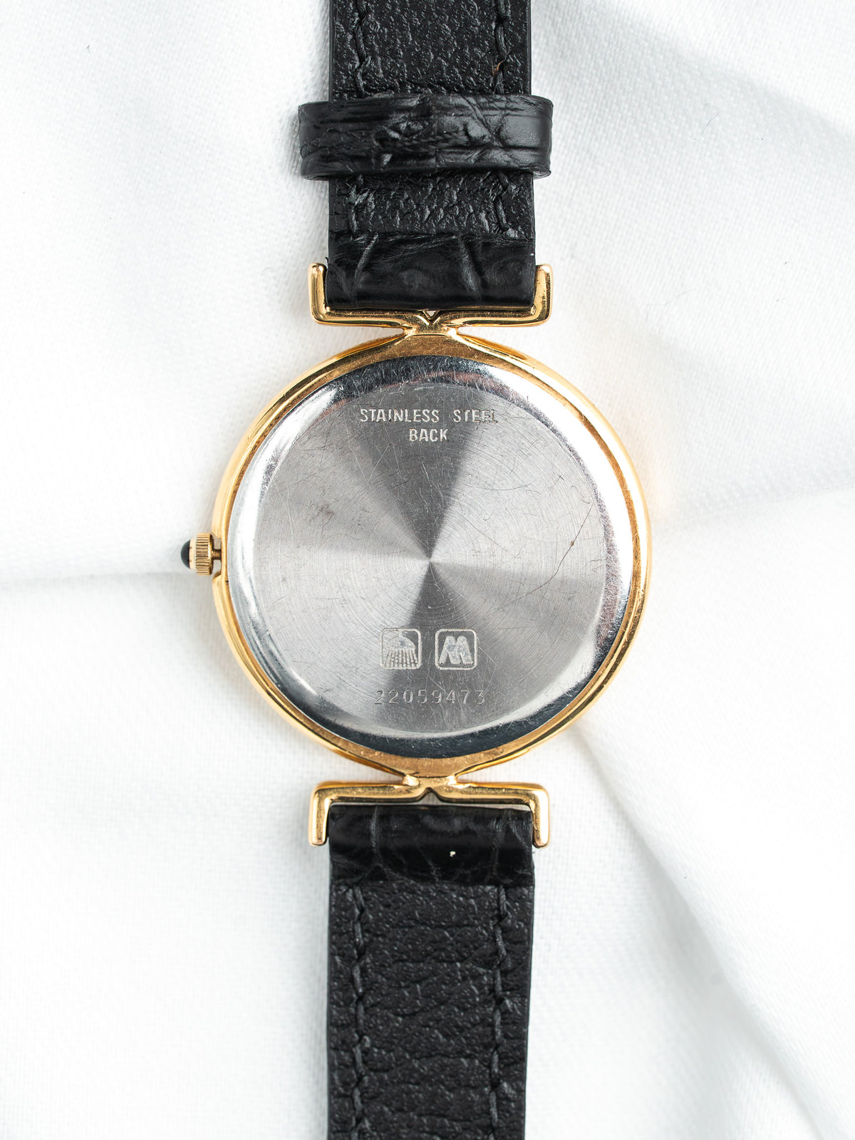 Vintage watch with gold case, stainless steel back, black leather strap