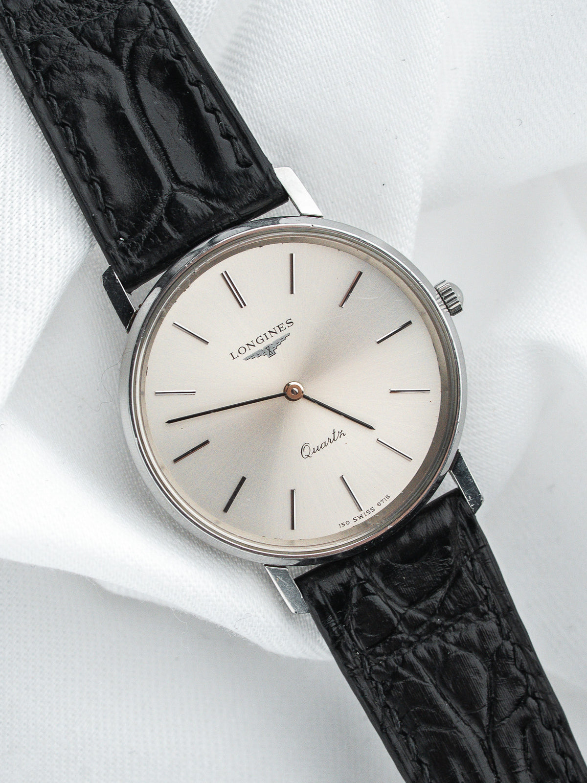 Montre Longines Quartz vintage, cadran argenté et bracelet en cuir noir grainé
