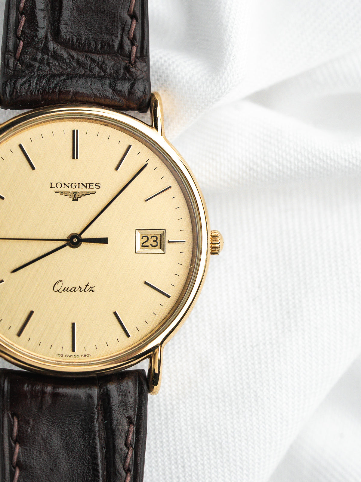 Montre Longines Quartz vintage, boîtier doré, cadran champagne et bracelet en cuir marron