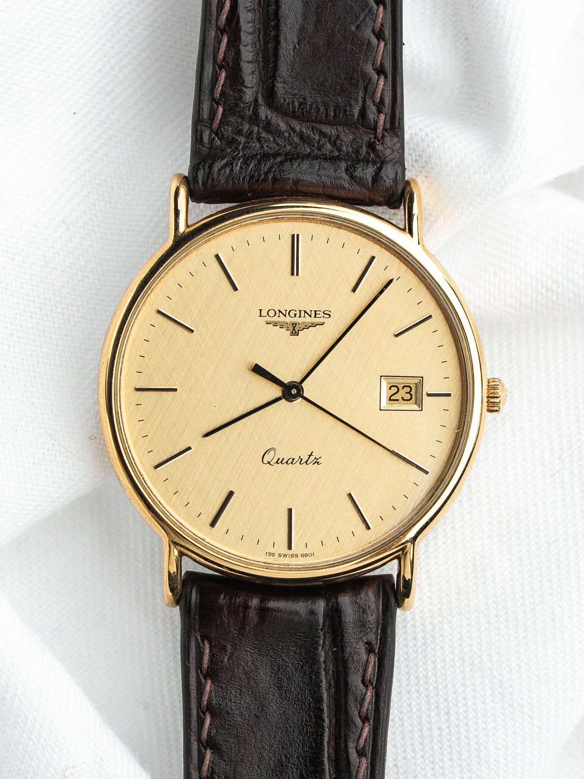 Montre Longines Quartz vintage, boîtier doré, cadran champagne et bracelet en cuir marron