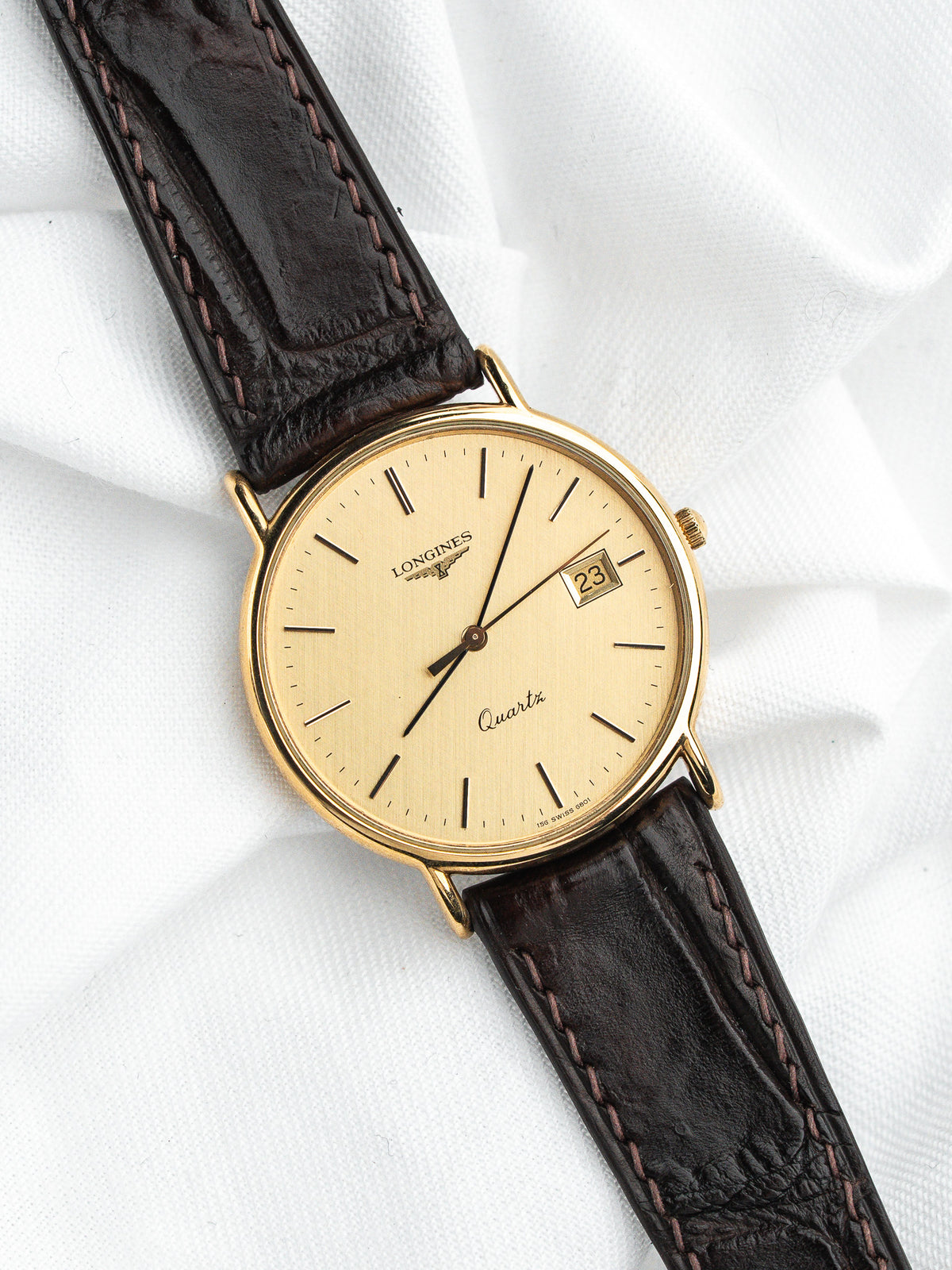 Montre Longines vintage à boîtier or, cadran champagne et bracelet en cuir marron
